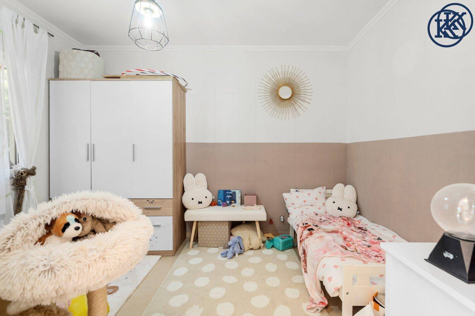 Kinderzimmer mit Einzelbett, Kleiderschrank und verspielter Dekoration, ideal für kleine Bewohner.
