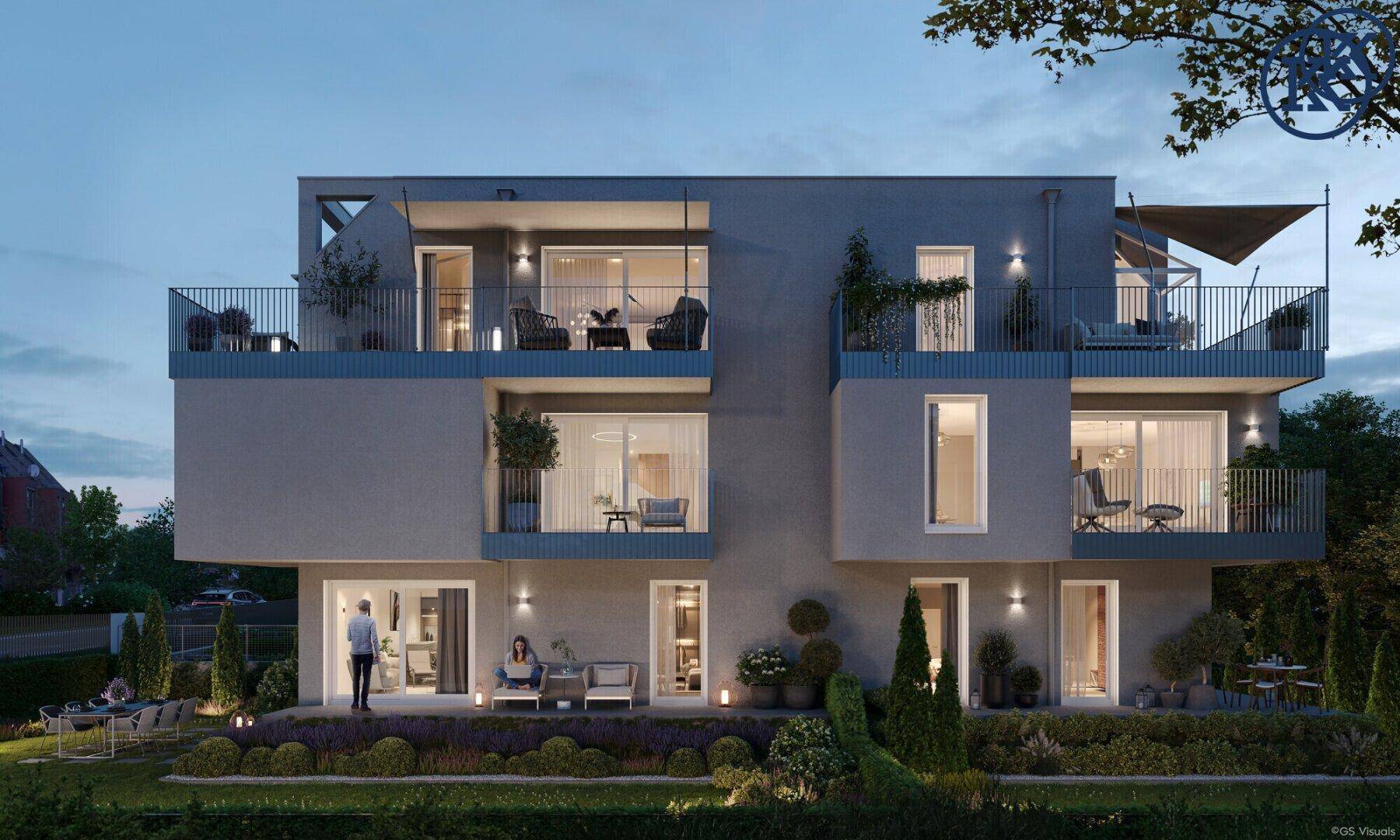 Abendliche Ansicht der modernen Wohnanlage mit beleuchteten Terrassen und einem einladenden Gartenbereich.