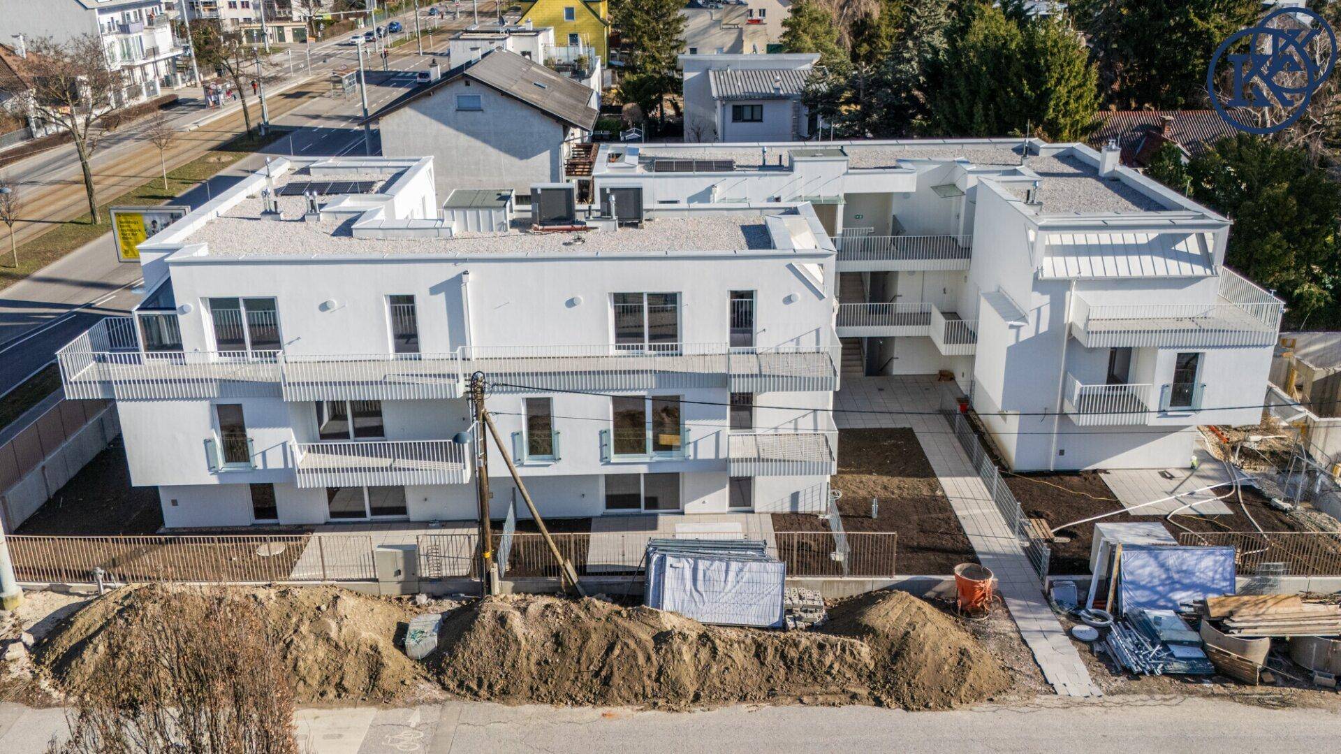Gesamtansicht des modernen Wohnkomplexes aus der Vogelperspektive mit umliegender Bebauung.