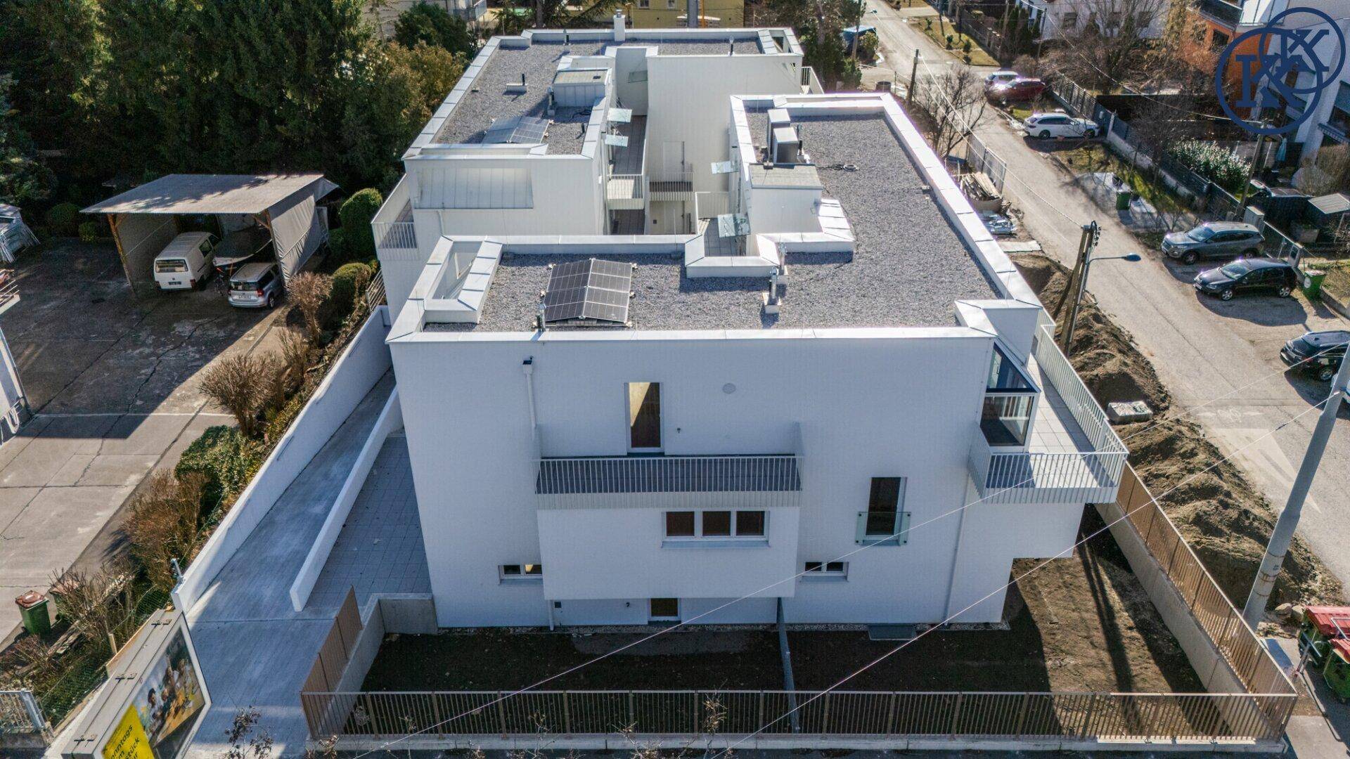Detaillierte Luftaufnahme der Flachdächer von Neubauten mit Photovoltaikanlage.