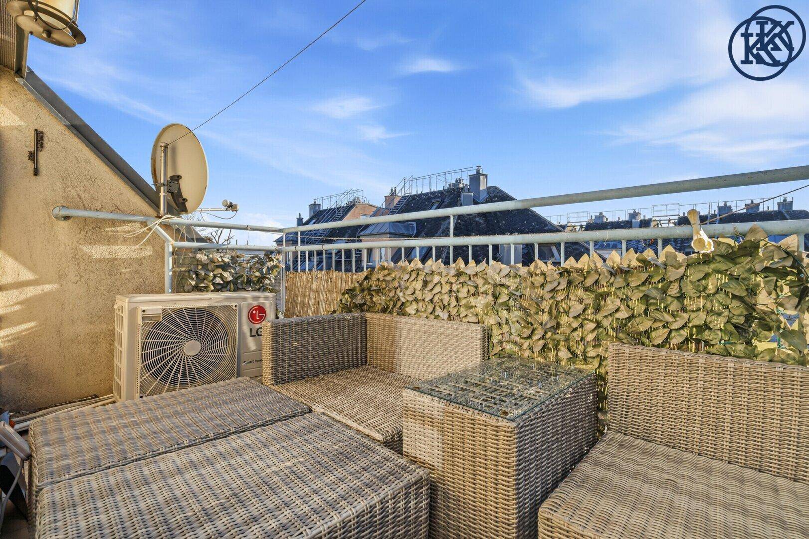 Dachterrasse mit bequemen Outdoor-Möbeln und Blick über die Dächer der Umgebung.