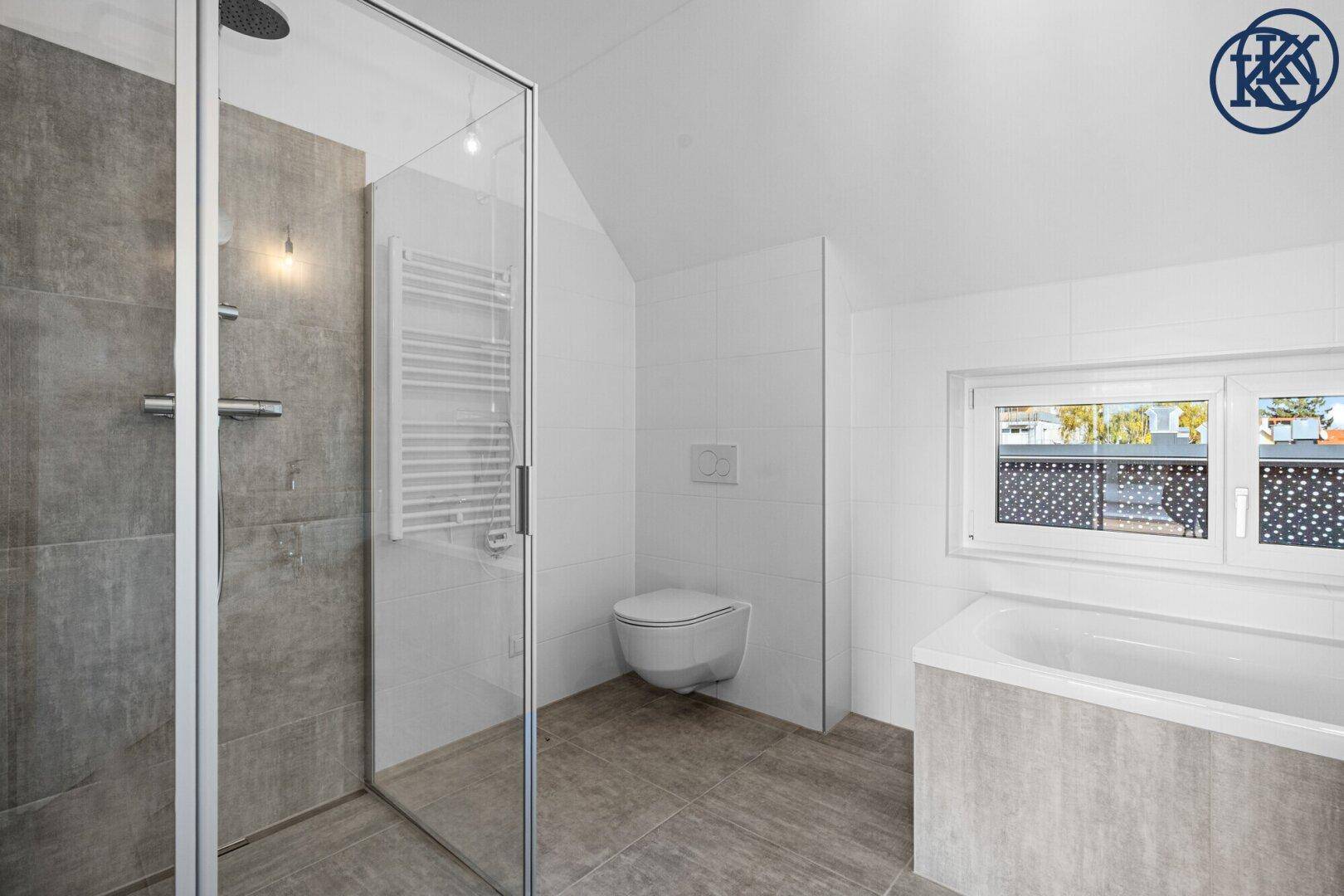 Modernes Badezimmer mit begehbarer Dusche, Badewanne, WC und beheiztem Handtuchhalter.
