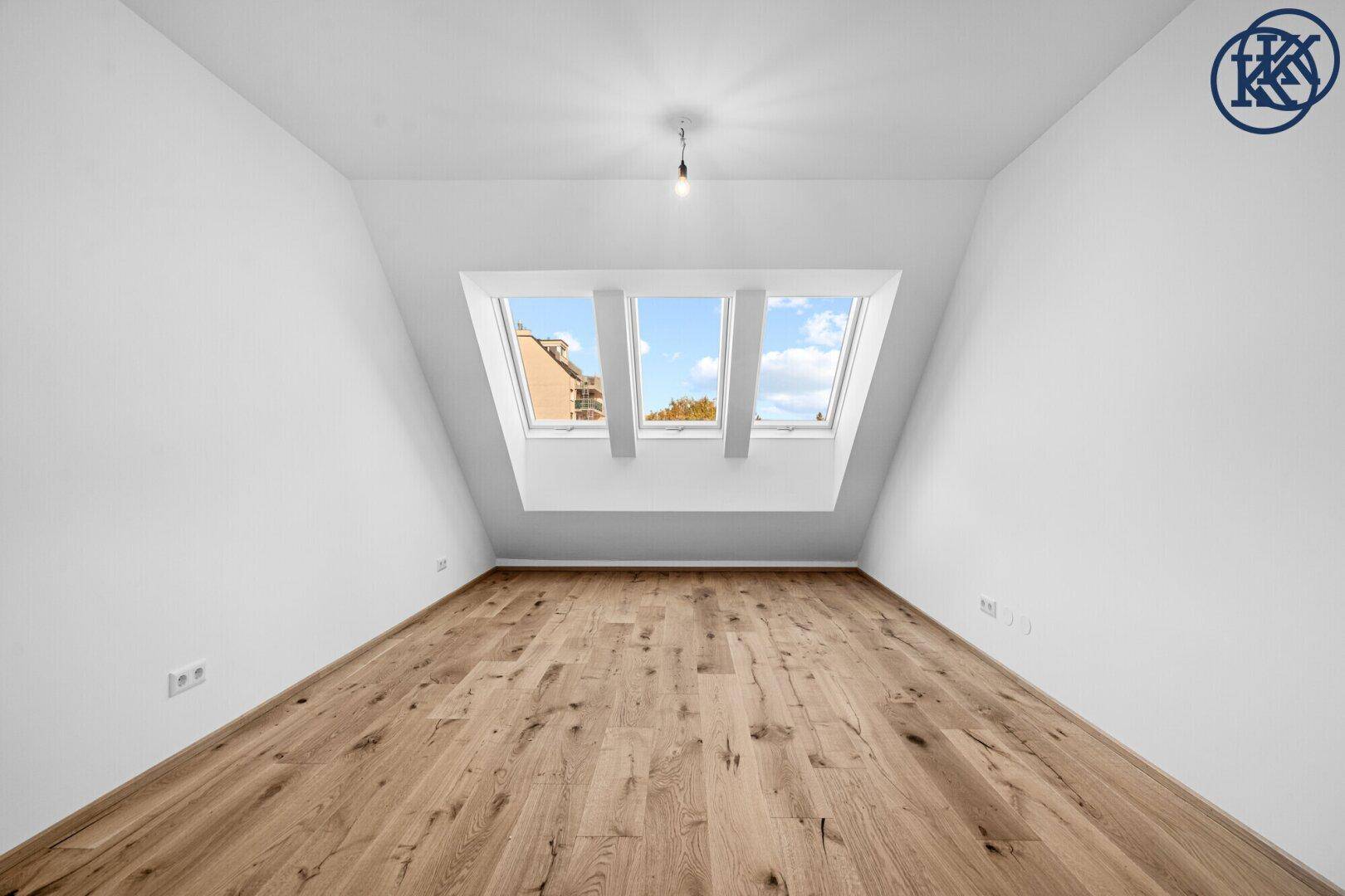 Helles Schlafzimmer mit Holzboden, Dachschrägen und drei Dachfenstern, ideal für natürliches Licht.