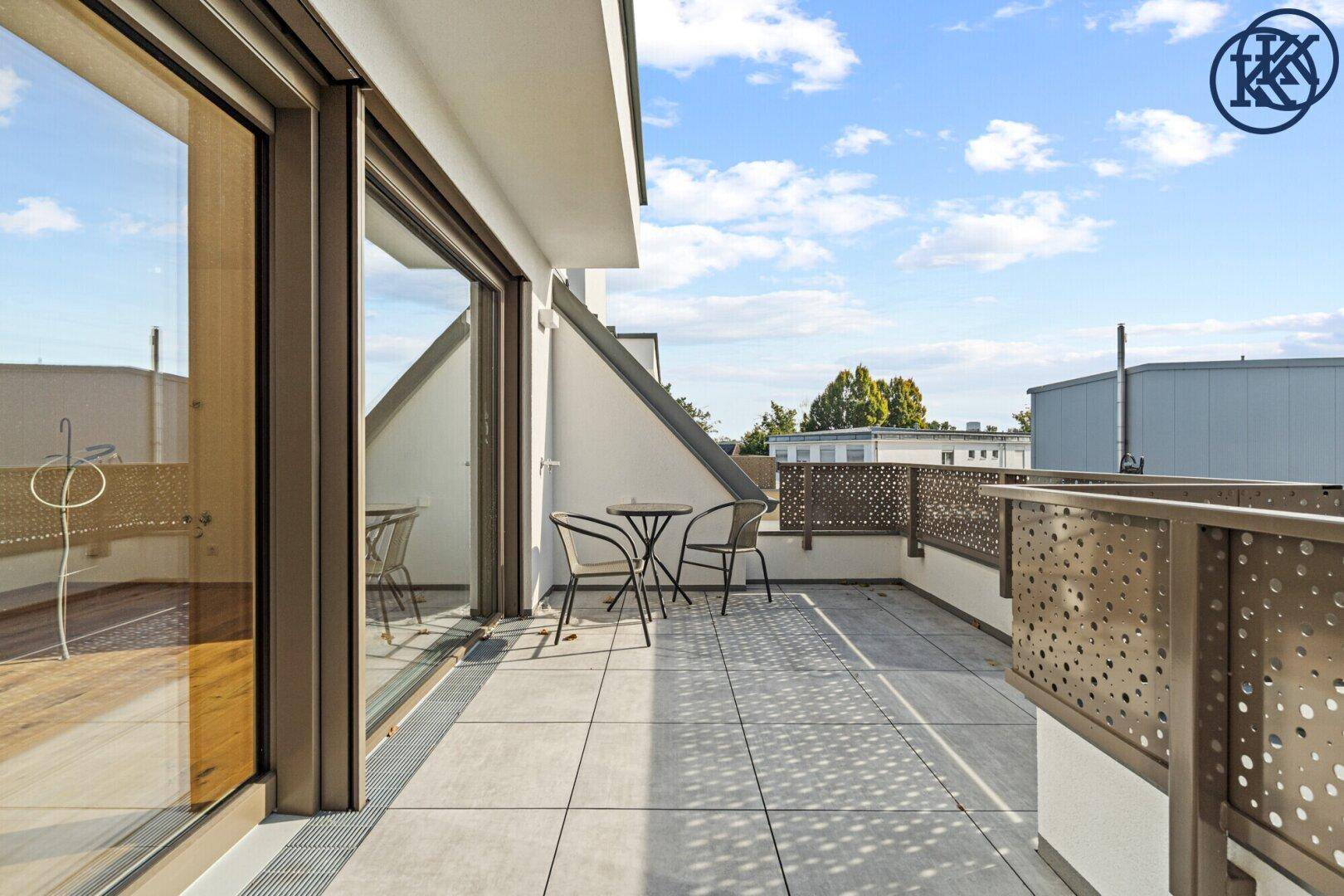 Sonnige Terrasse mit Fliesenboden und Zugang vom Innenbereich, ideal für Entspannung.