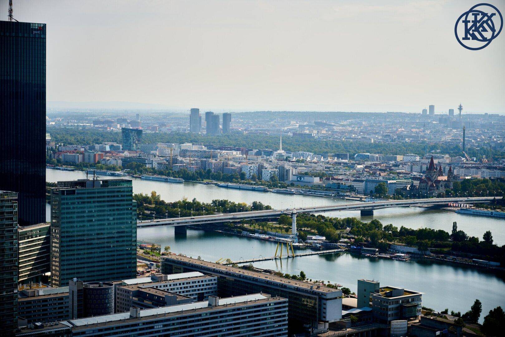 Weitläufiger Blick über die Stadt mit Fluss, Brücken und urbaner Bebauung.