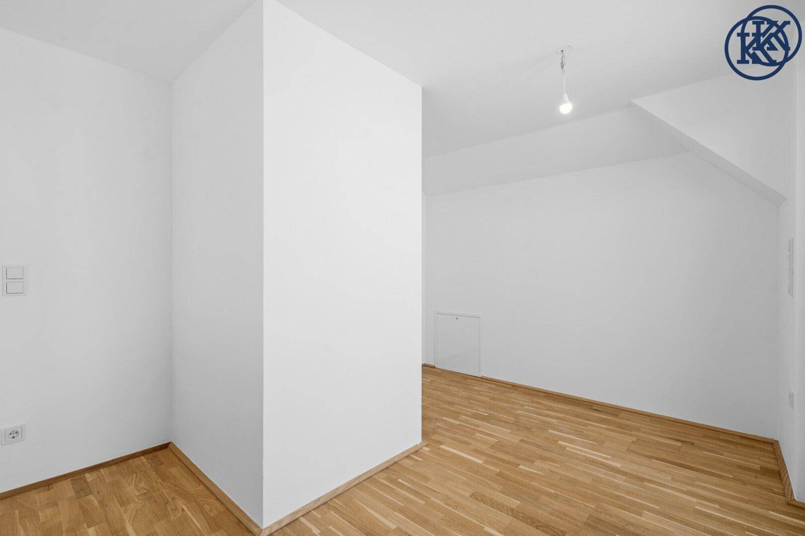 Leerer Raum mit Holzboden und weißen Wänden, bereit für individuelle Gestaltung.