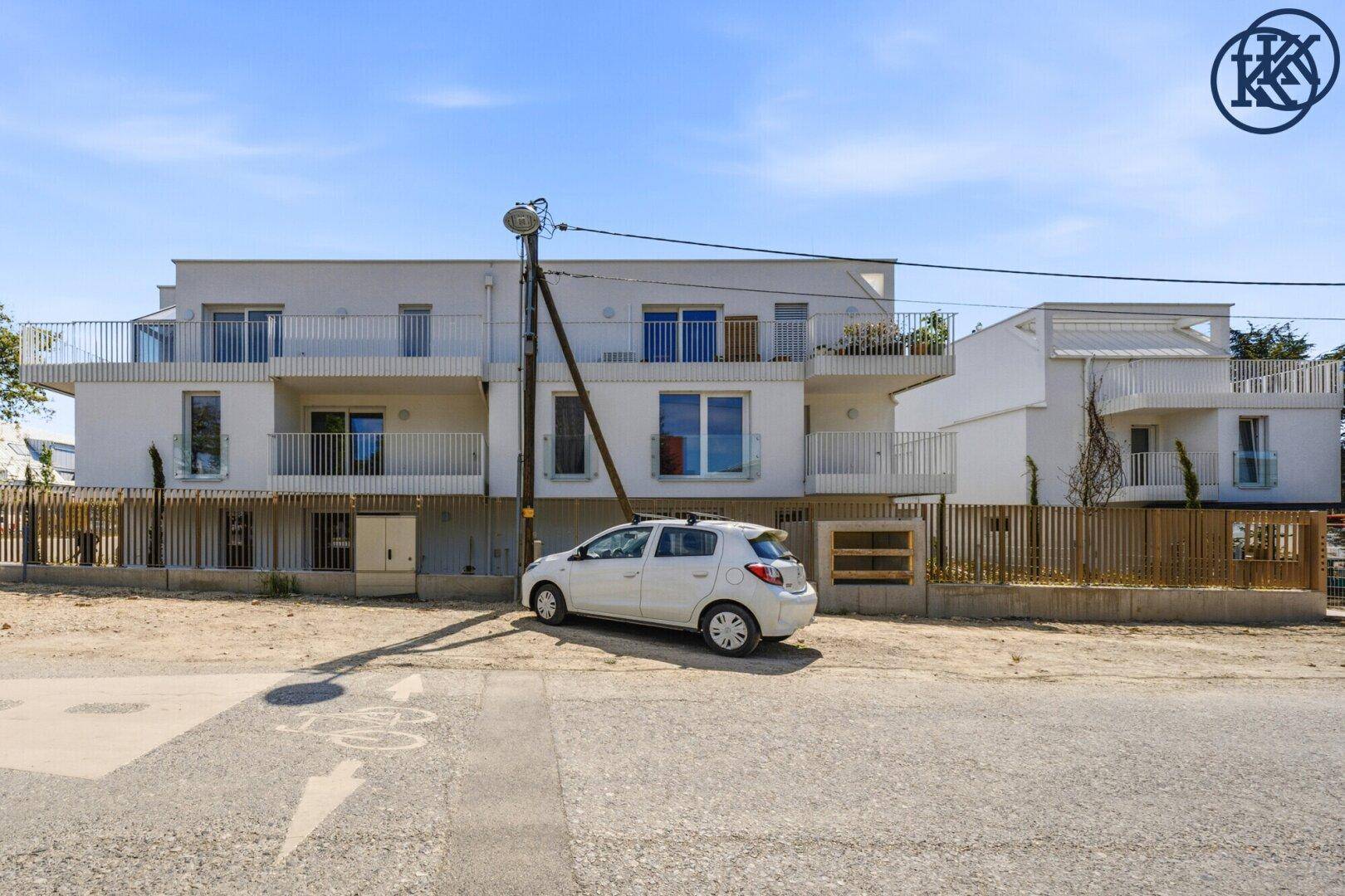 Neubau-Wohngebäude mit Balkonen und moderner Architektur von der Straßenseite aus gesehen.