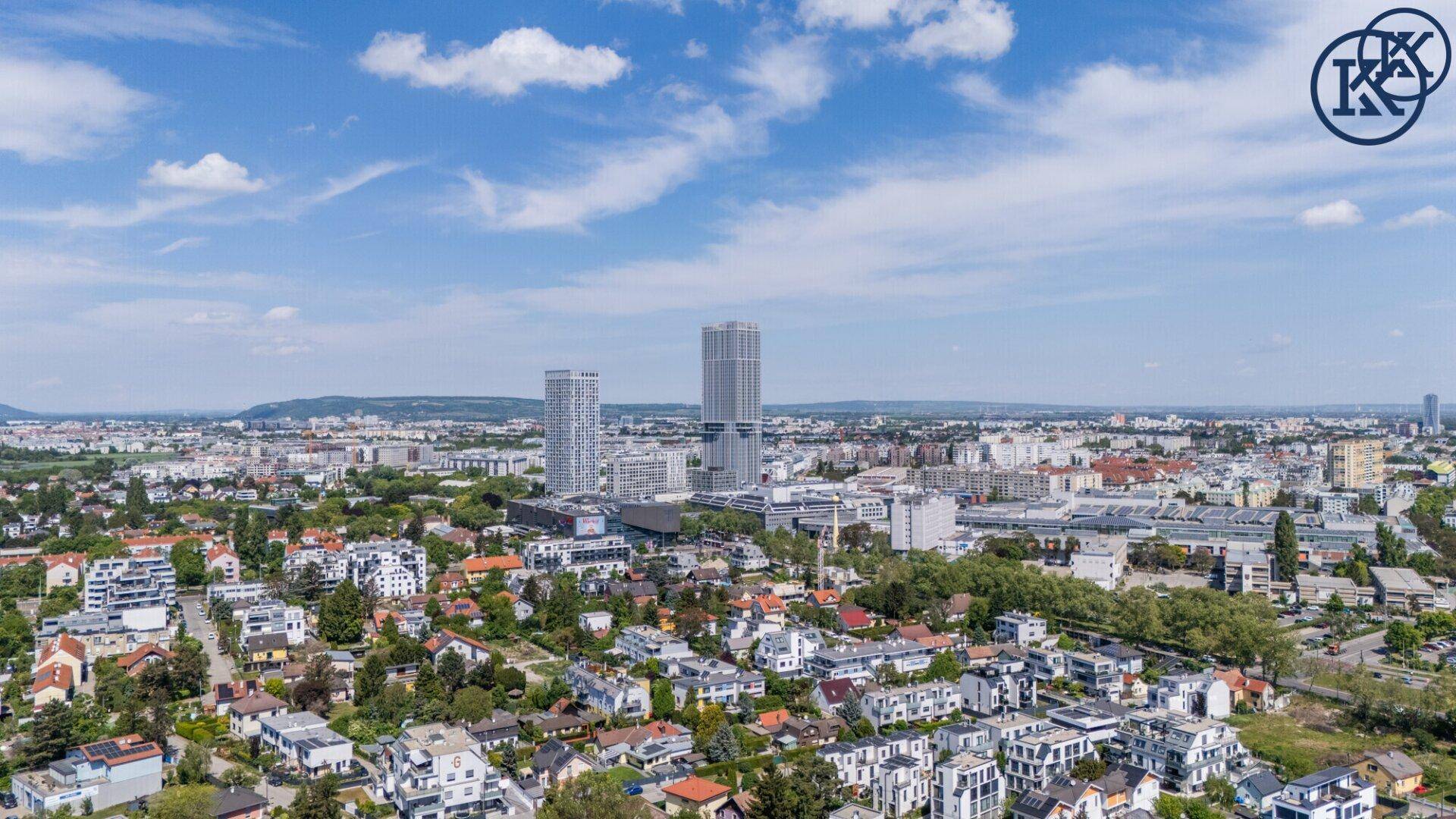 Weitläufiger Stadtblick mit modernen Hochhäusern und Wohngebäuden unter blauem Himmel.