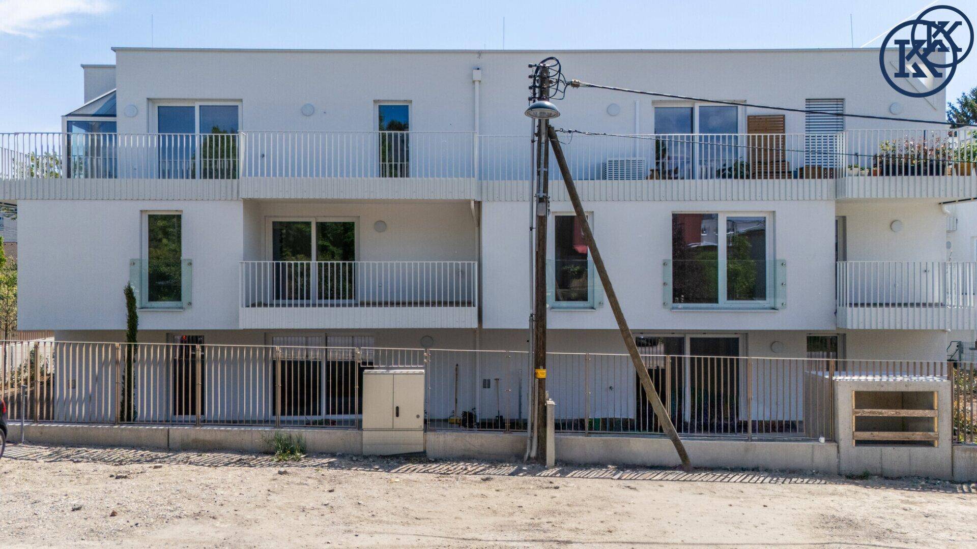Neubau-Wohngebäude mit Balkonen und moderner Architektur von der Straßenseite aus gesehen.