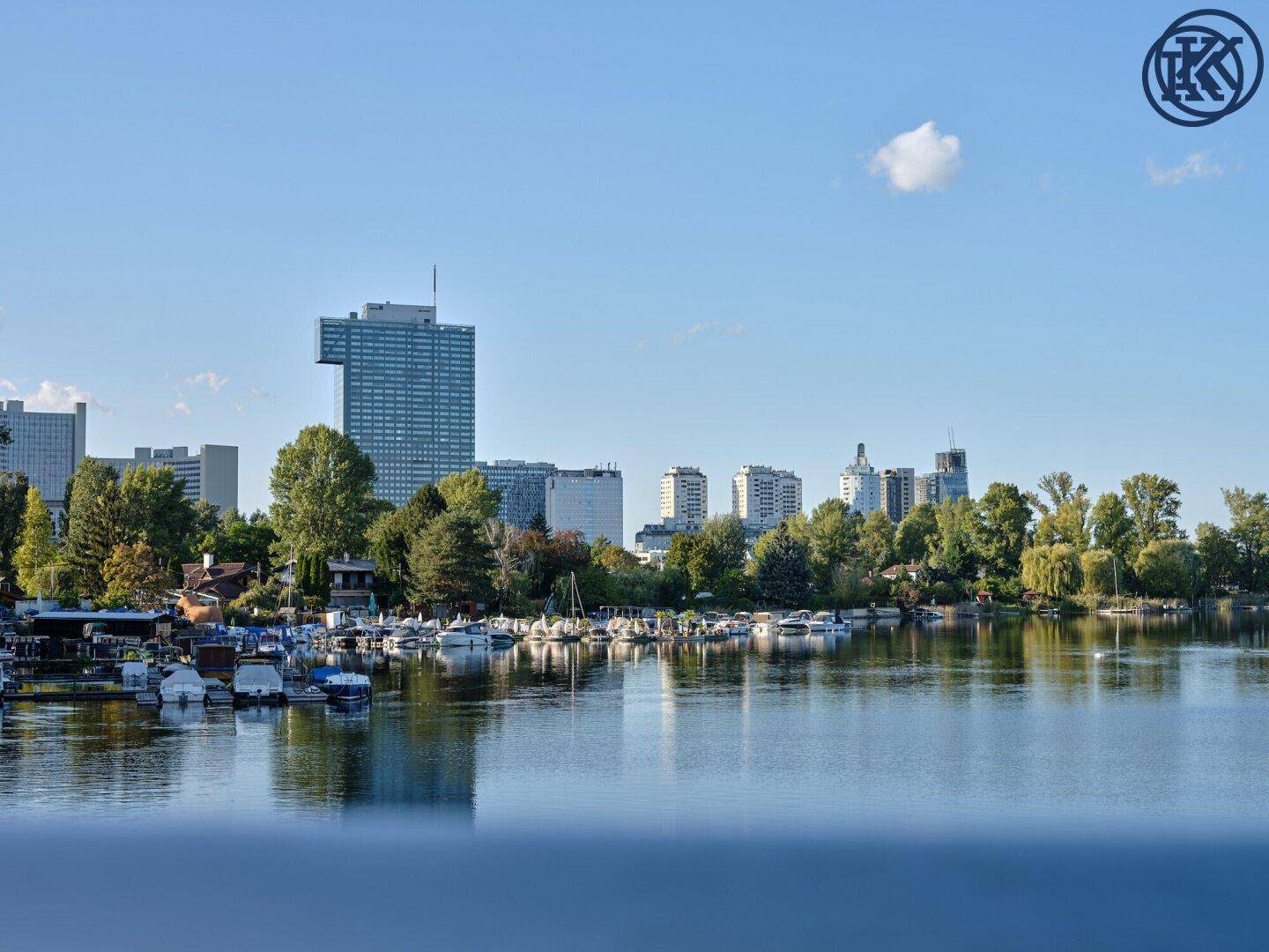 Panoramablick über den See mit zahlreichen Booten und der städtischen Skyline im Hintergrund.