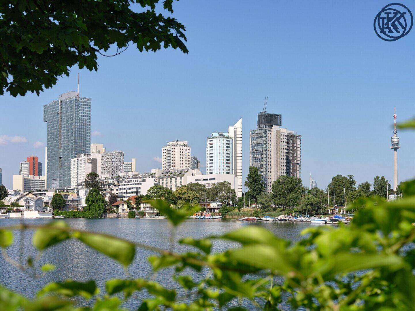 Klarer Blick über den See auf die beeindruckende Skyline der Stadt an einem sonnigen Tag.