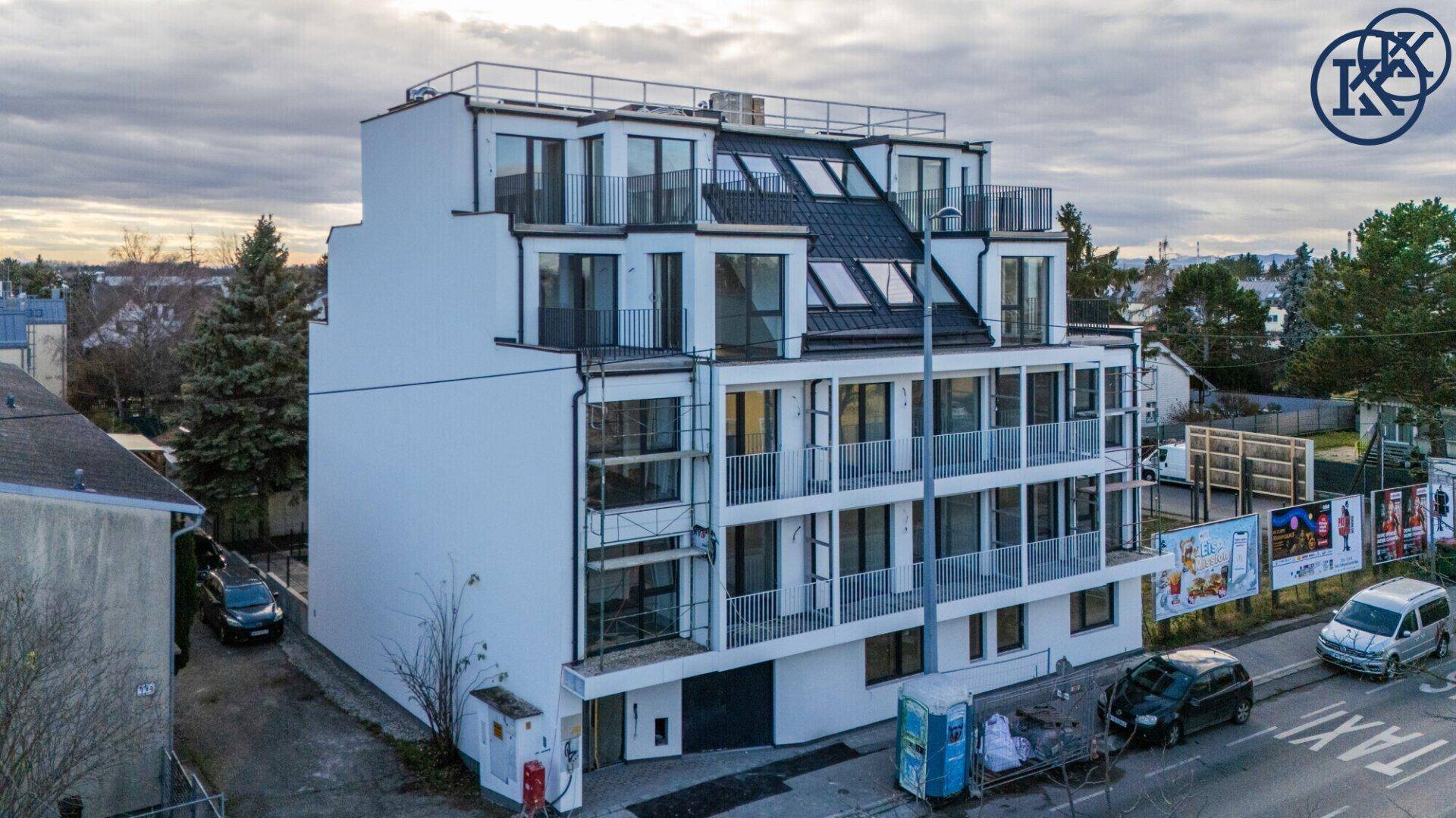 Neubau-Wohnhaus mit moderner Architektur, großen Fenstern und Balkonen.