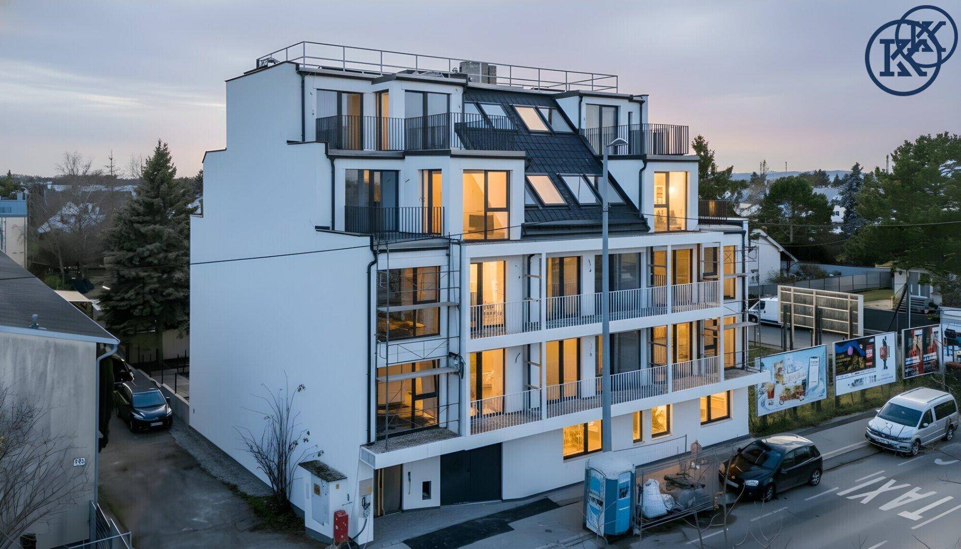Modernes Wohngebäude bei Sonnenuntergang mit beleuchteten Innenräumen und Balkonen.