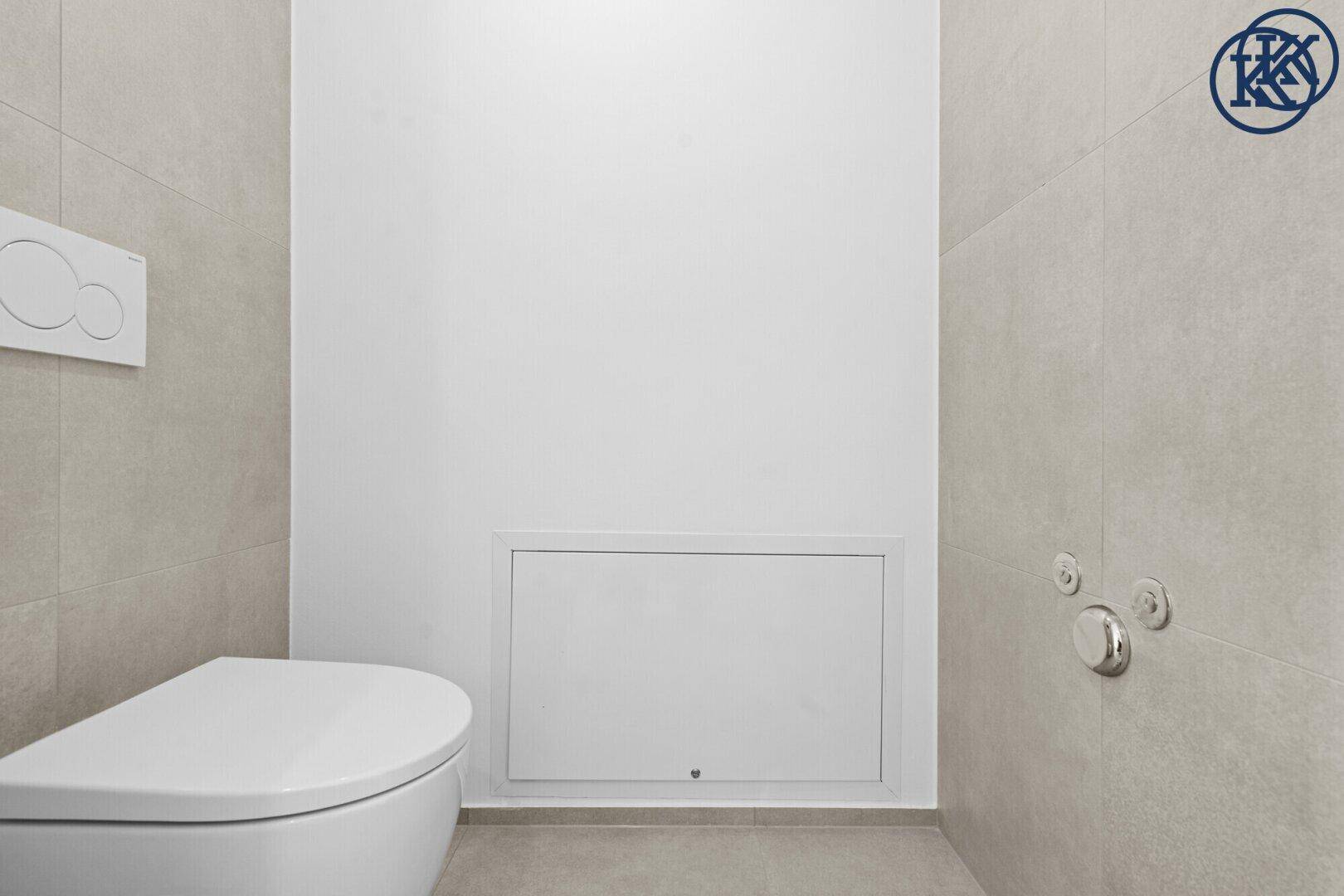Modernes WC mit wandhängender Toilette und hellgrauen Fliesen an Wänden und Boden.