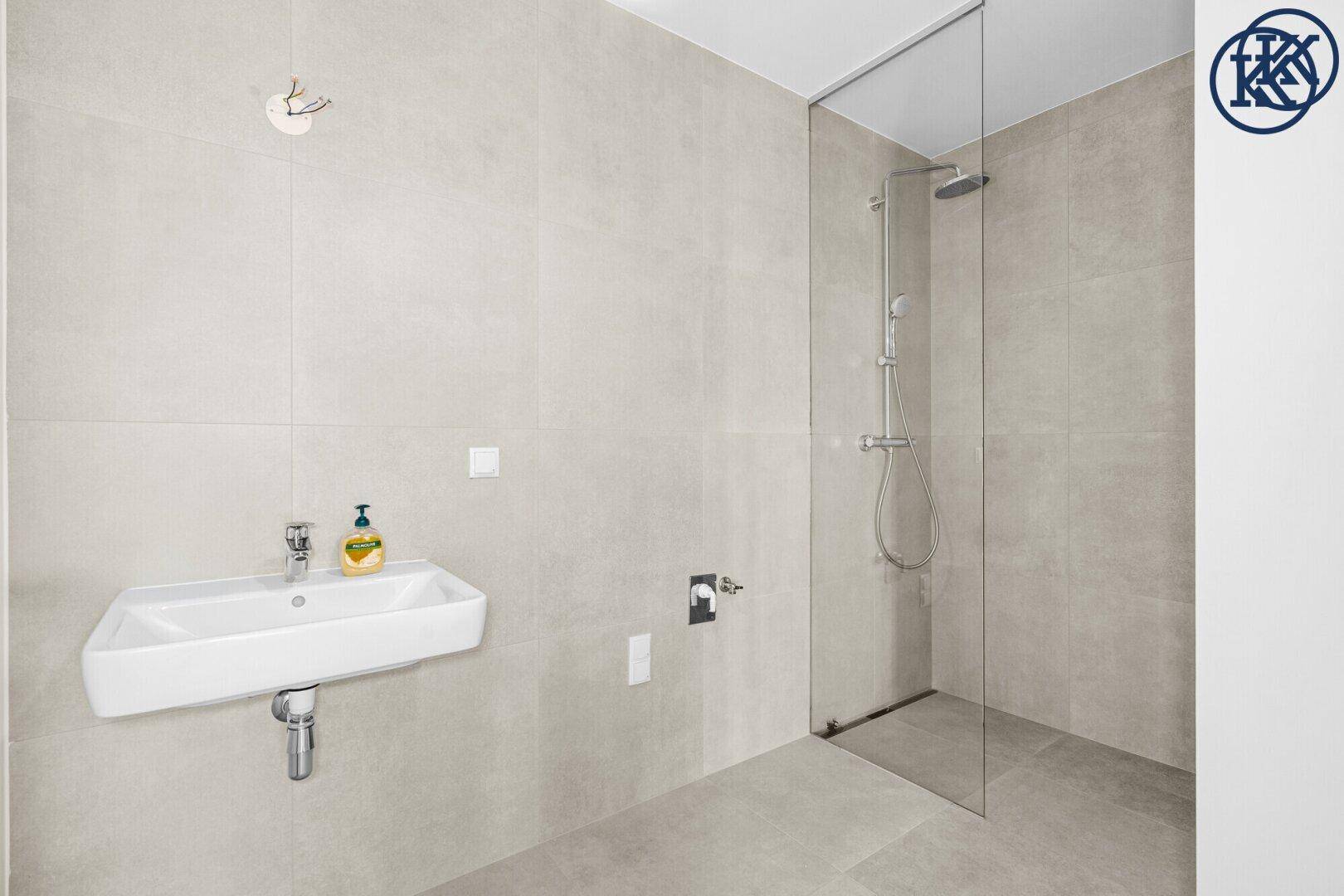 Modernes Badezimmer mit wandhängendem Waschbecken und begehbarer Dusche.
