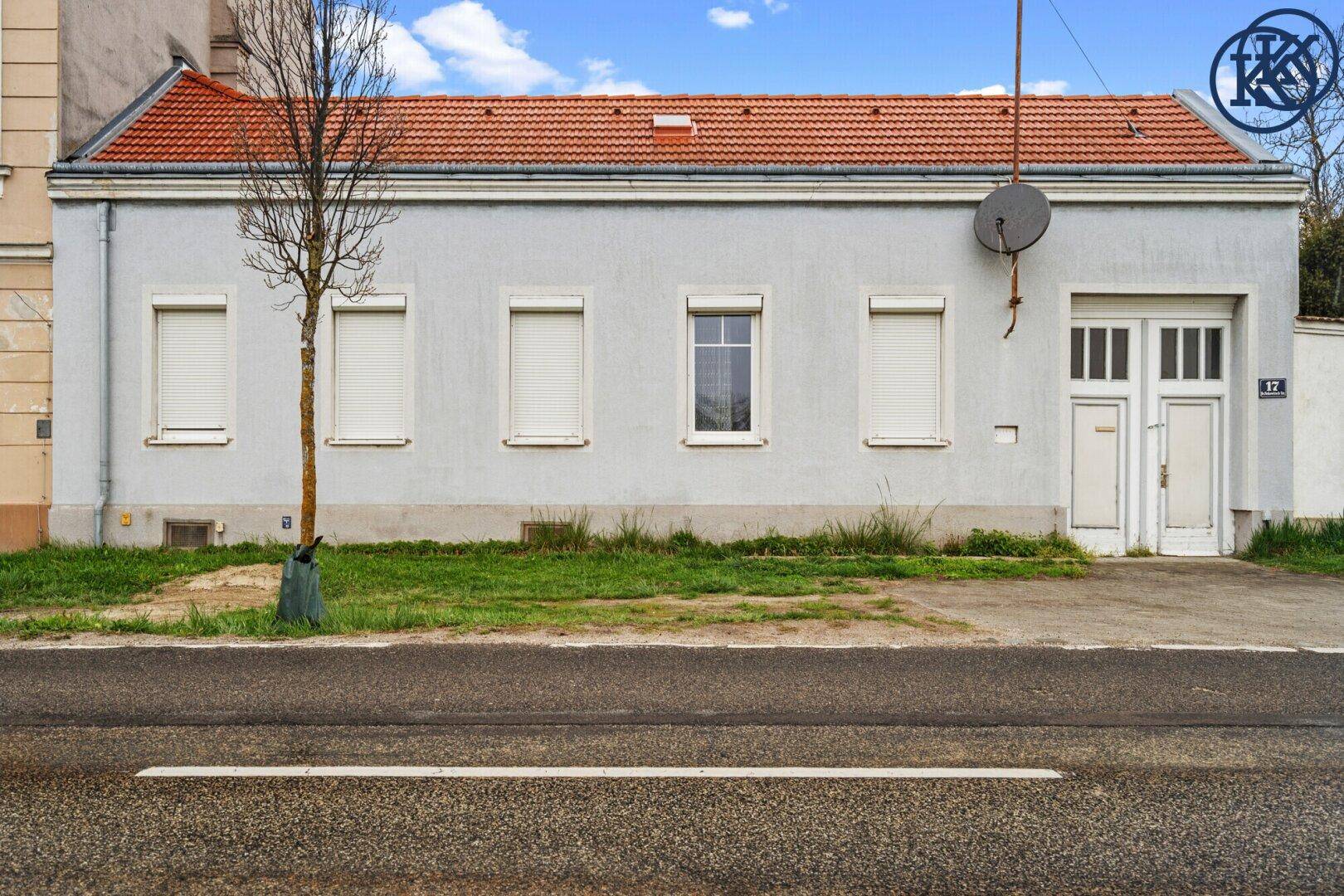 Fassade des Hauses mit roten Dachziegeln und Rollläden an den Fenstern.