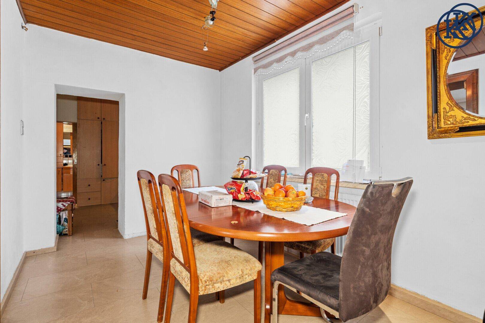 Gemütliches Esszimmer mit Holztisch, Stühlen und einer Holzdecke.