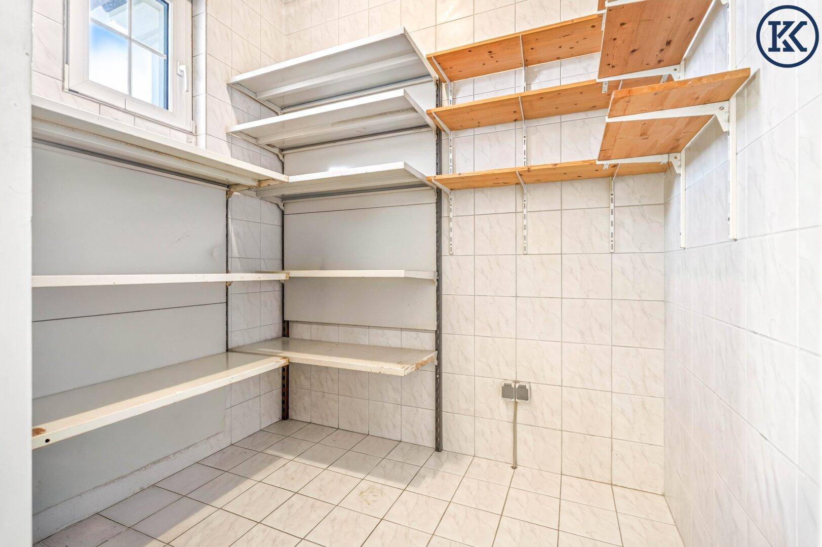 Praktische Speisekammer mit weißen Fliesen und mehreren Regalböden für Vorräte und Lagerung.