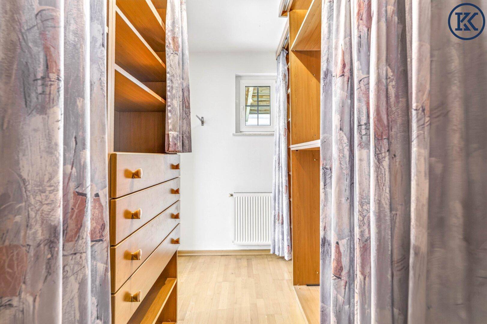 Schmaler Raum mit eingebauten Holzregalen und Schubladen, ideal als Ankleide- oder Abstellraum.