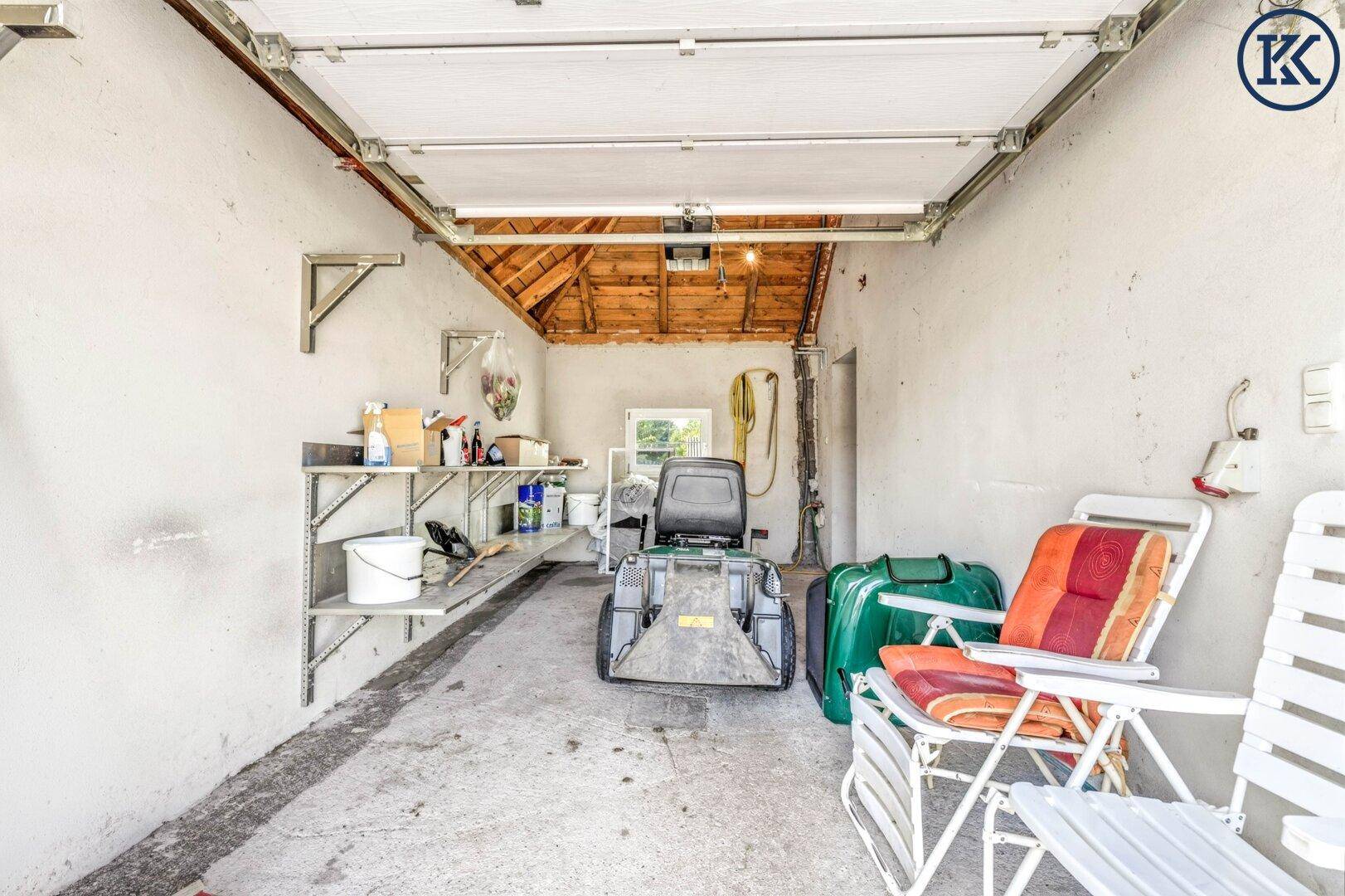 Innenansicht einer Garage oder Werkstatt mit Regalen für Werkzeuge und einem Fenster.