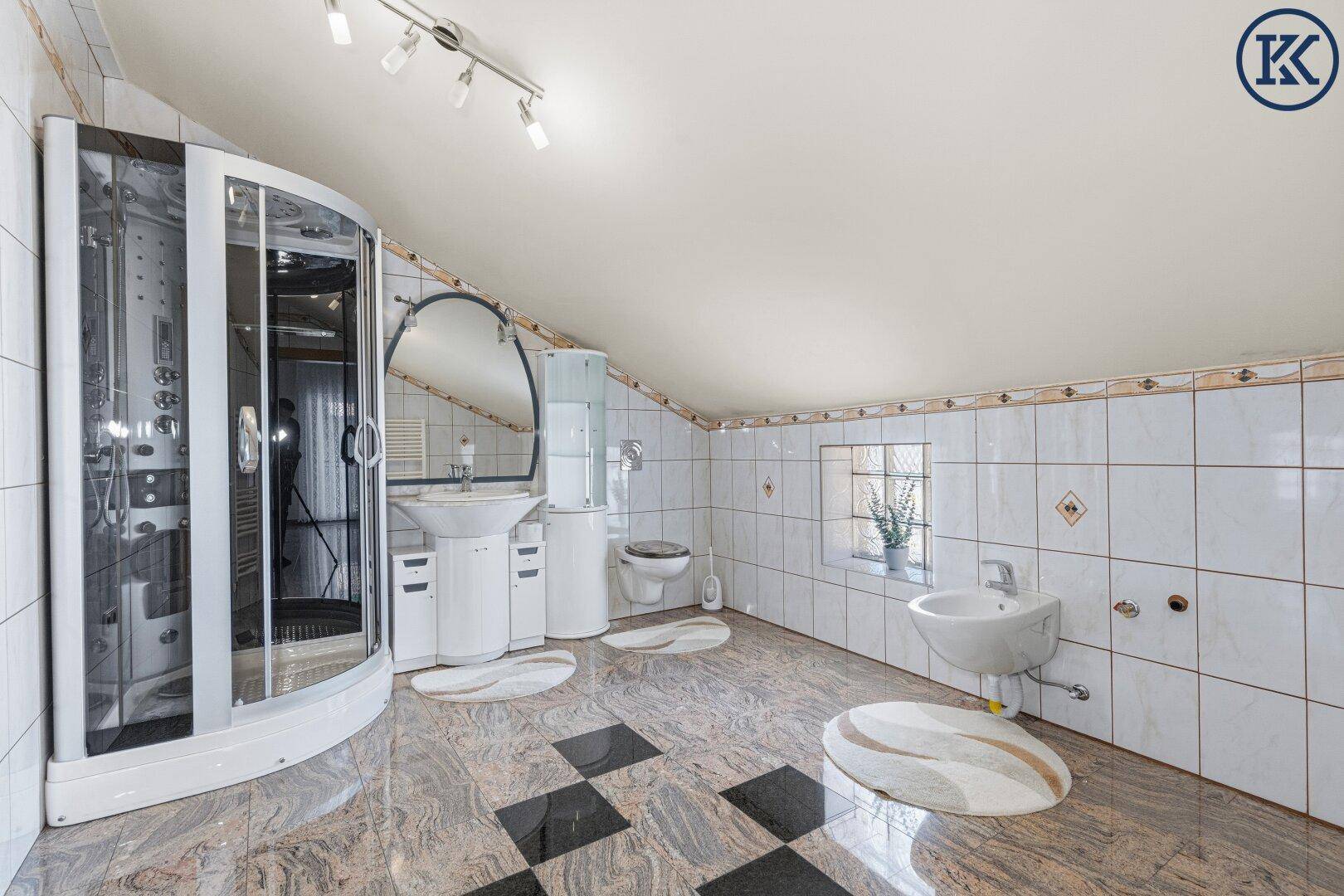Geräumiges Badezimmer mit Duschkabine, Bidet und Granitboden im Dachgeschoss.