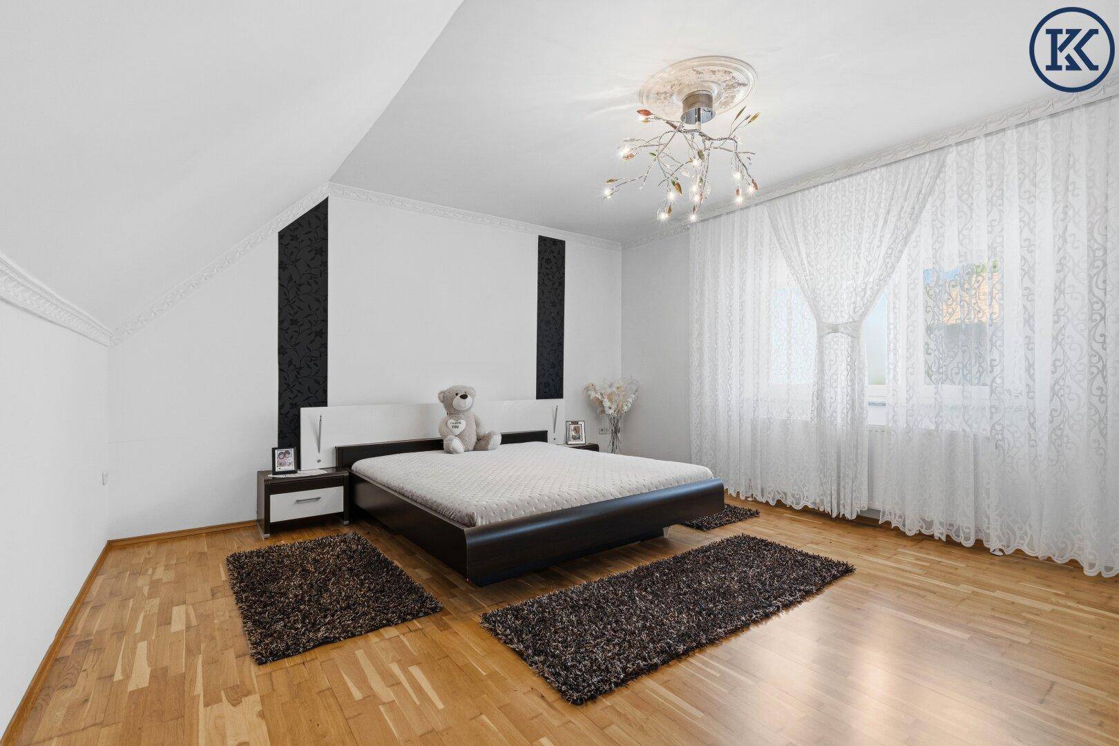Modernes Schlafzimmer mit Parkettboden, Dachschräge und minimalistischer Einrichtung.