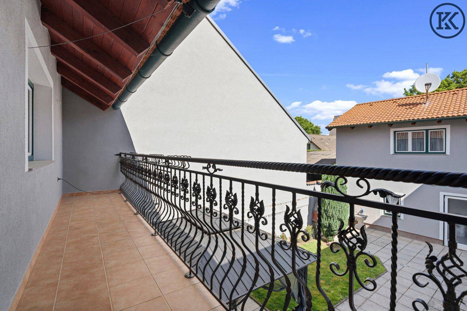 Langer Balkon mit schmiedeeisernem Geländer und Blick auf den Innenhof.