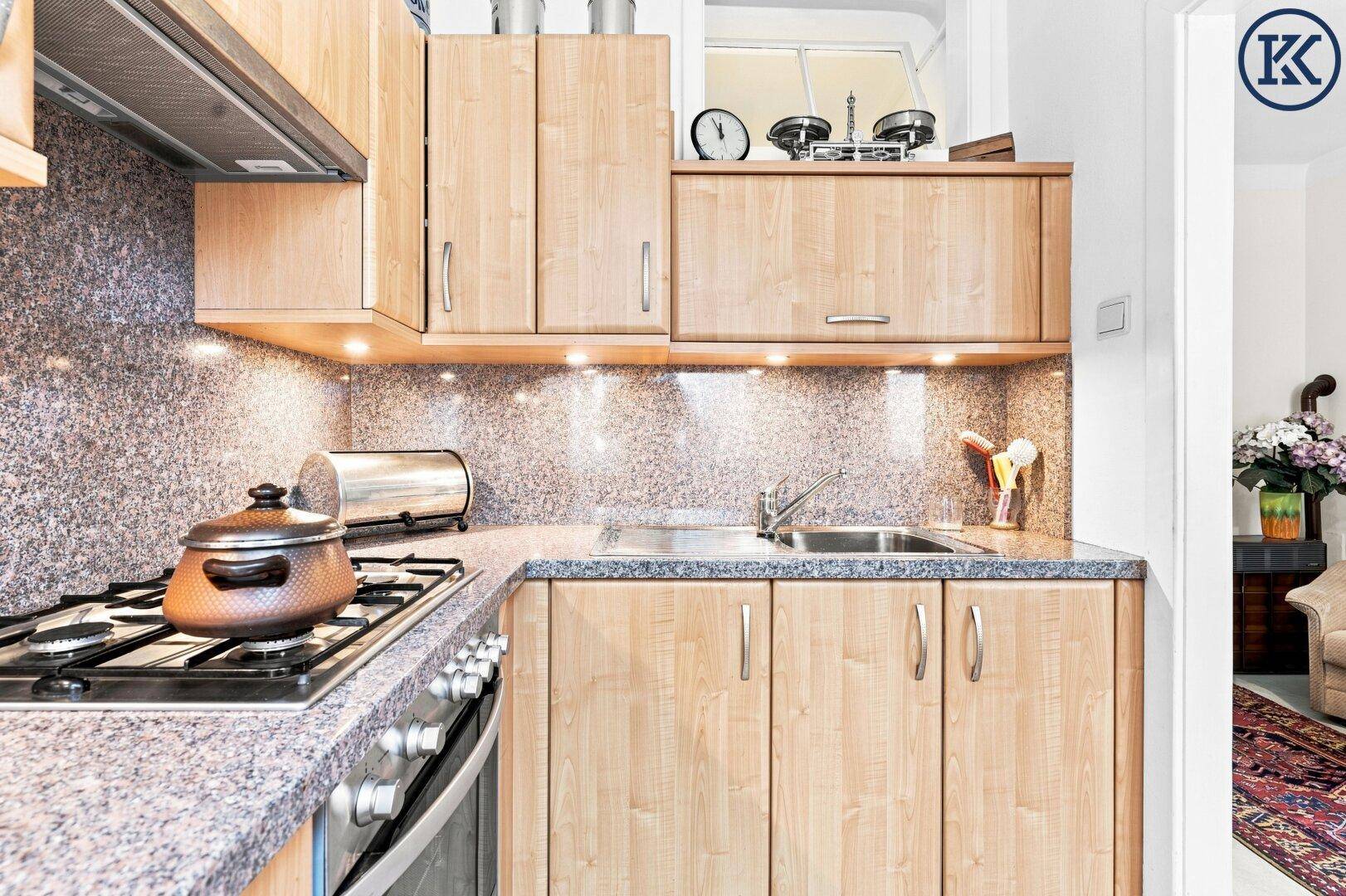 Funktionale Holzküche mit Granitarbeitsplatte, Spüle und Gasherd in gutem Zustand.