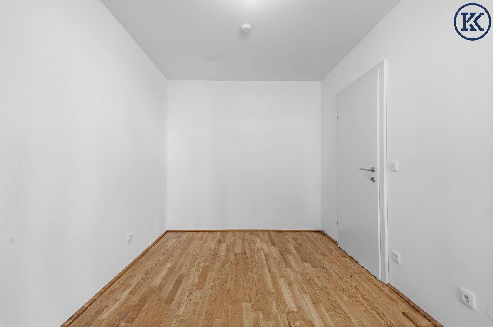 Leerer Raum mit weißen Wänden und hellem Holzplankenboden, bereit zur individuellen Gestaltung.