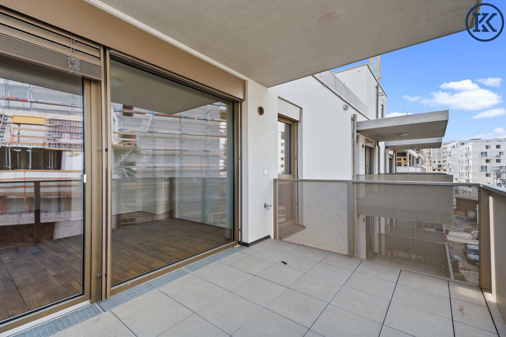 Geräumiger Balkon mit Fliesenboden und Schiebetüren zum Innenbereich der Wohnung.