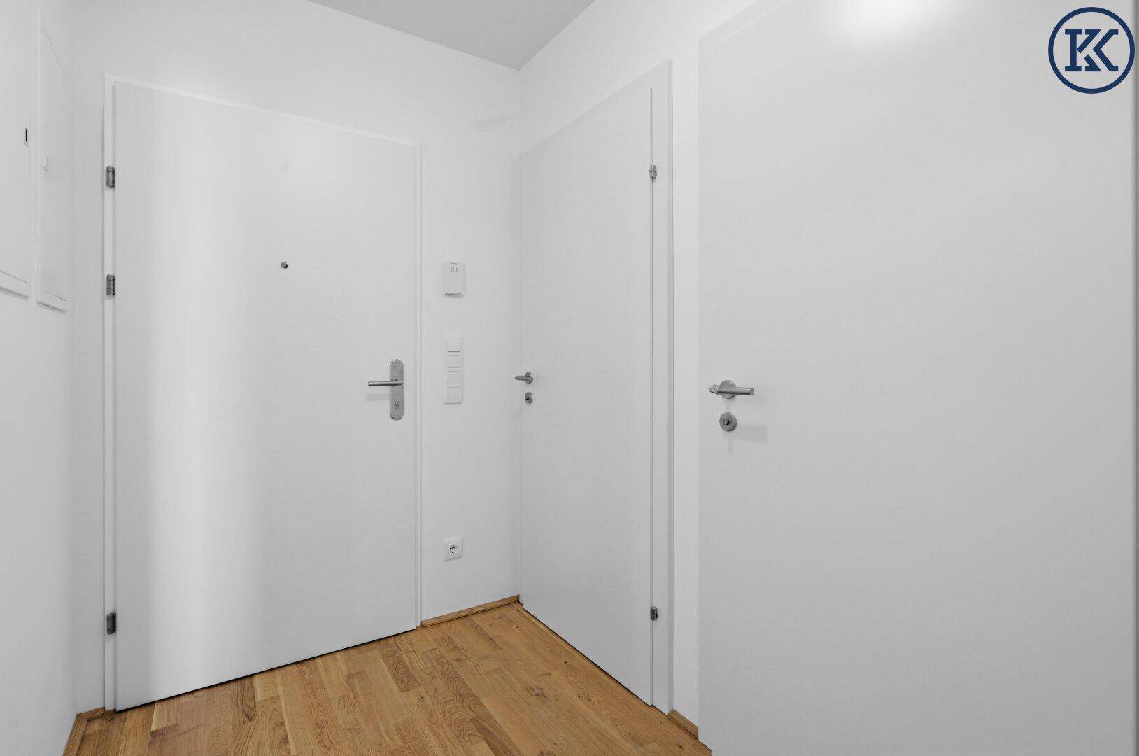 Eingangsbereich der Wohnung mit Holzboden und weißen Türen.