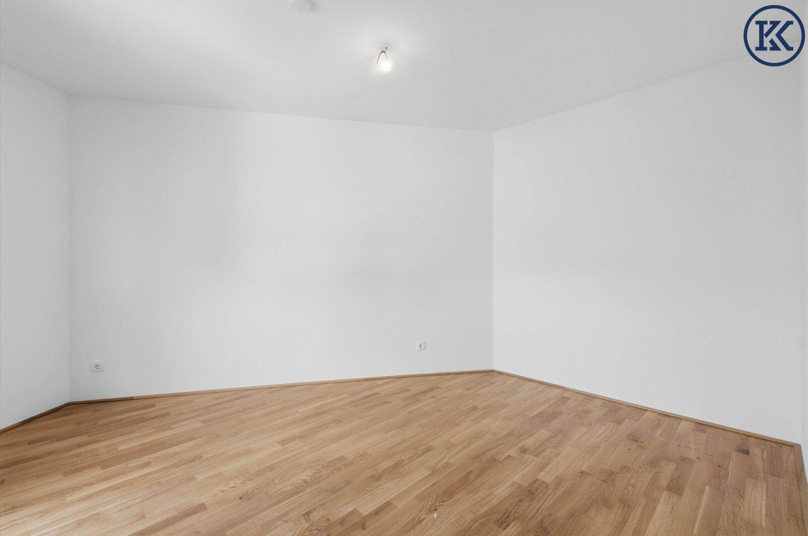 Geräumiges Schlafzimmer mit hellem Parkettboden und weißen Wänden, bereit zur Einrichtung.