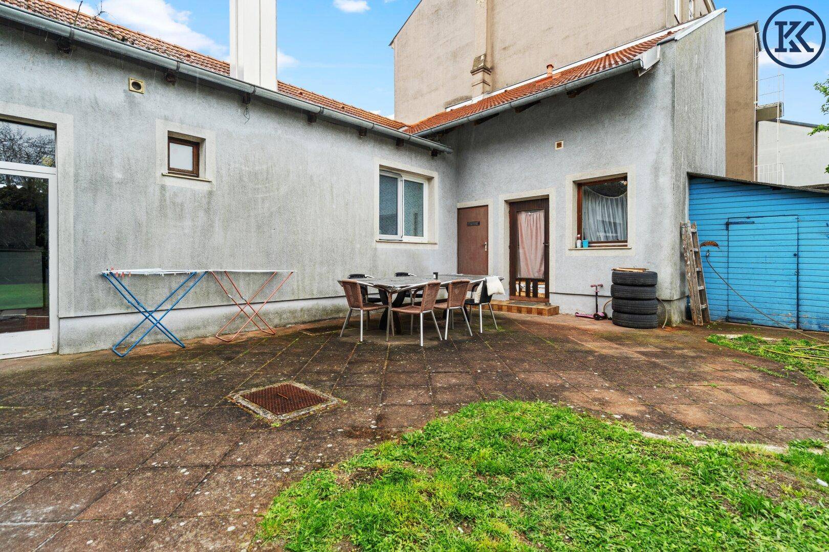 Geräumige Terrasse mit Gartenmöbeln und Zugang zum Haus.