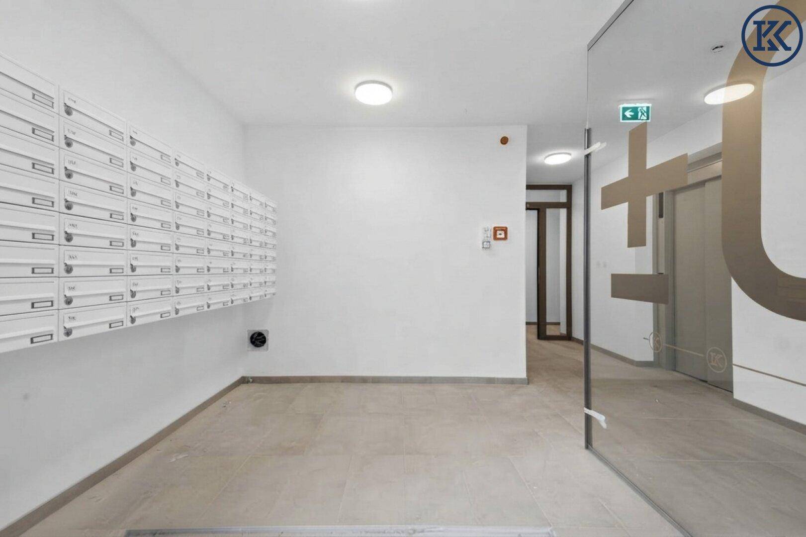 Heller Eingangsbereich mit vielen Briefkästen an der Wand und modernem Fliesenboden, führt zu weiteren Räumen.