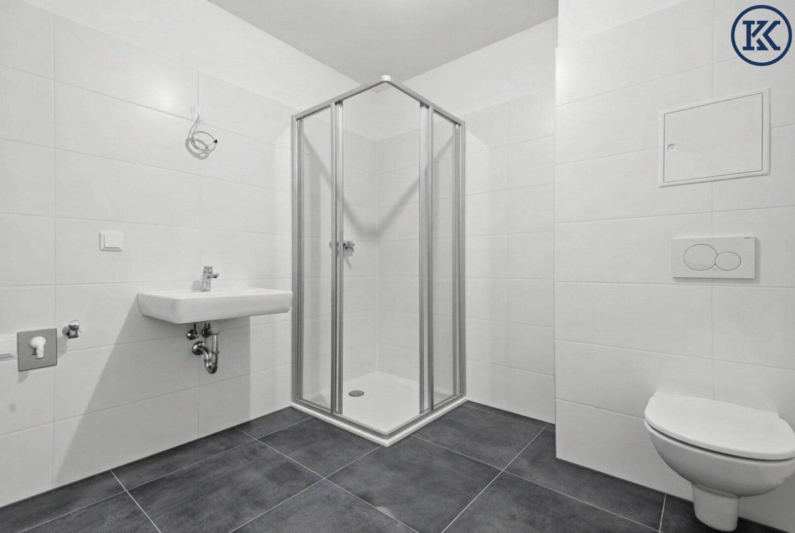 Modernes Badezimmer mit Eckdusche, Waschbecken und wandhängendem WC, ausgestattet mit hellen Wandfliesen.