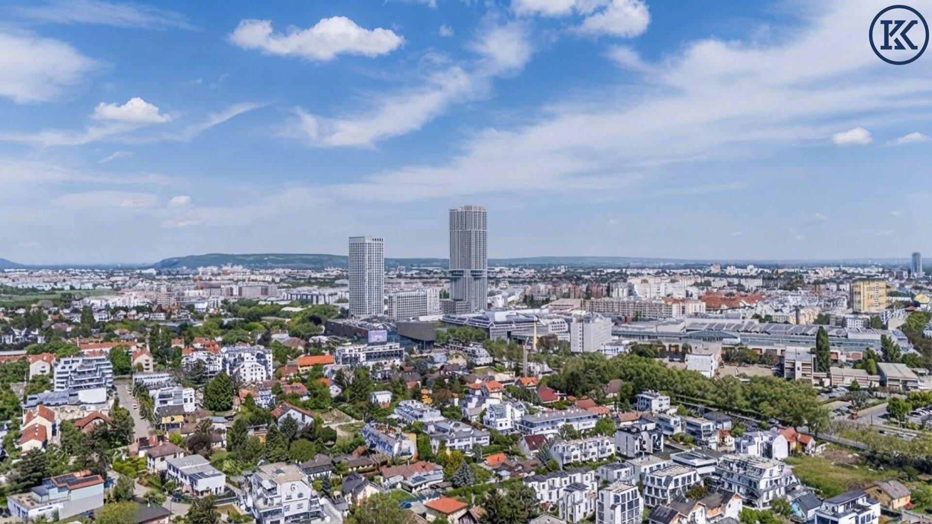 Weitläufiger Blick über eine Stadtlandschaft mit Wohngebäuden und Hochhäusern am Horizont.