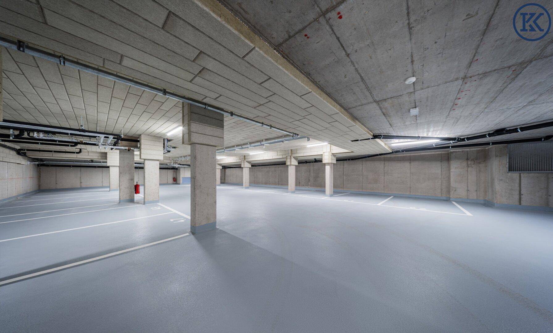 Geräumige Tiefgarage mit vielen Stellplätzen und Betonwänden, ideal für Bewohnerfahrzeuge.