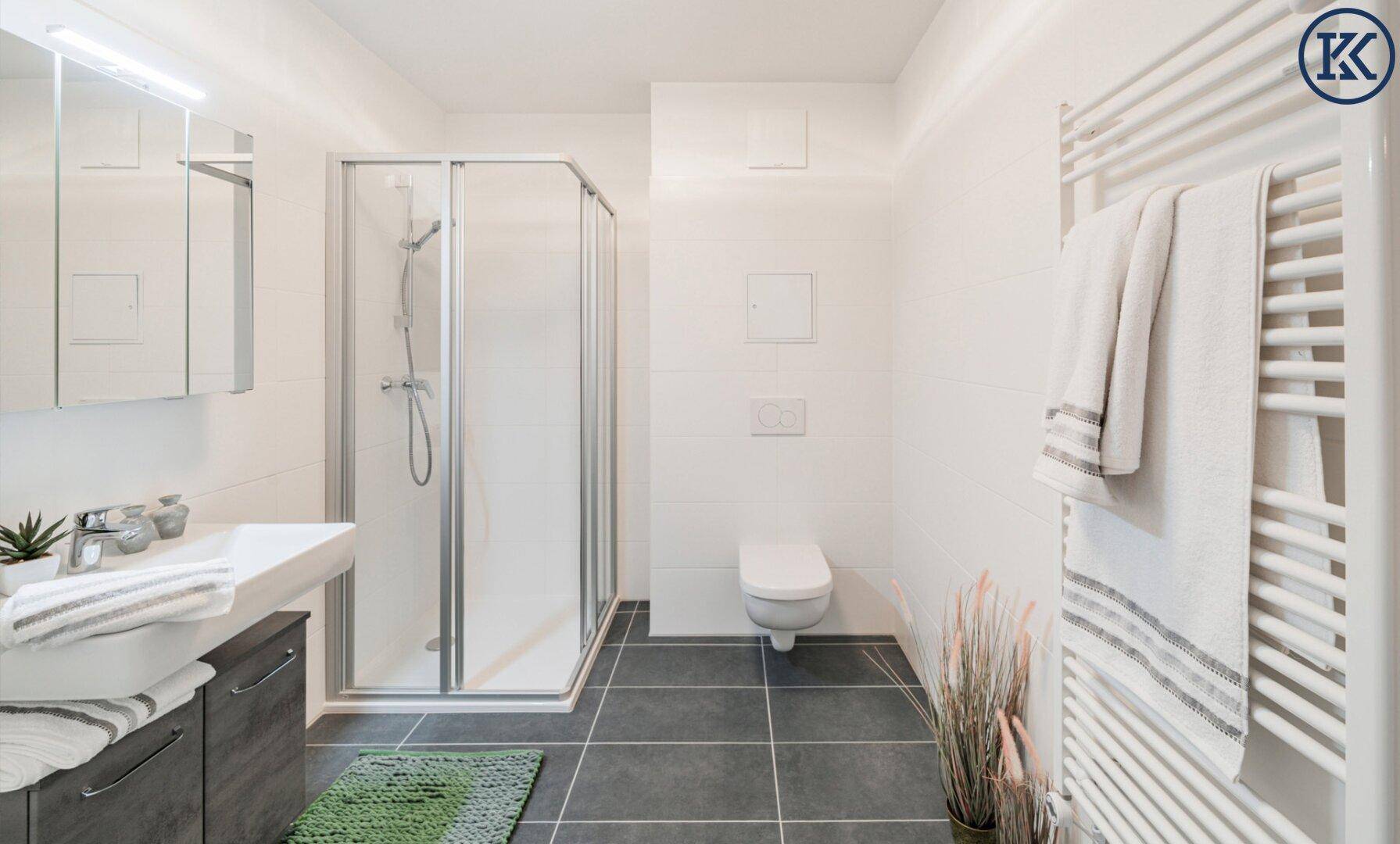 Modernes Badezimmer mit Duschkabine, Wand-WC, Einzelwaschbecken und beheiztem Handtuchhalter.