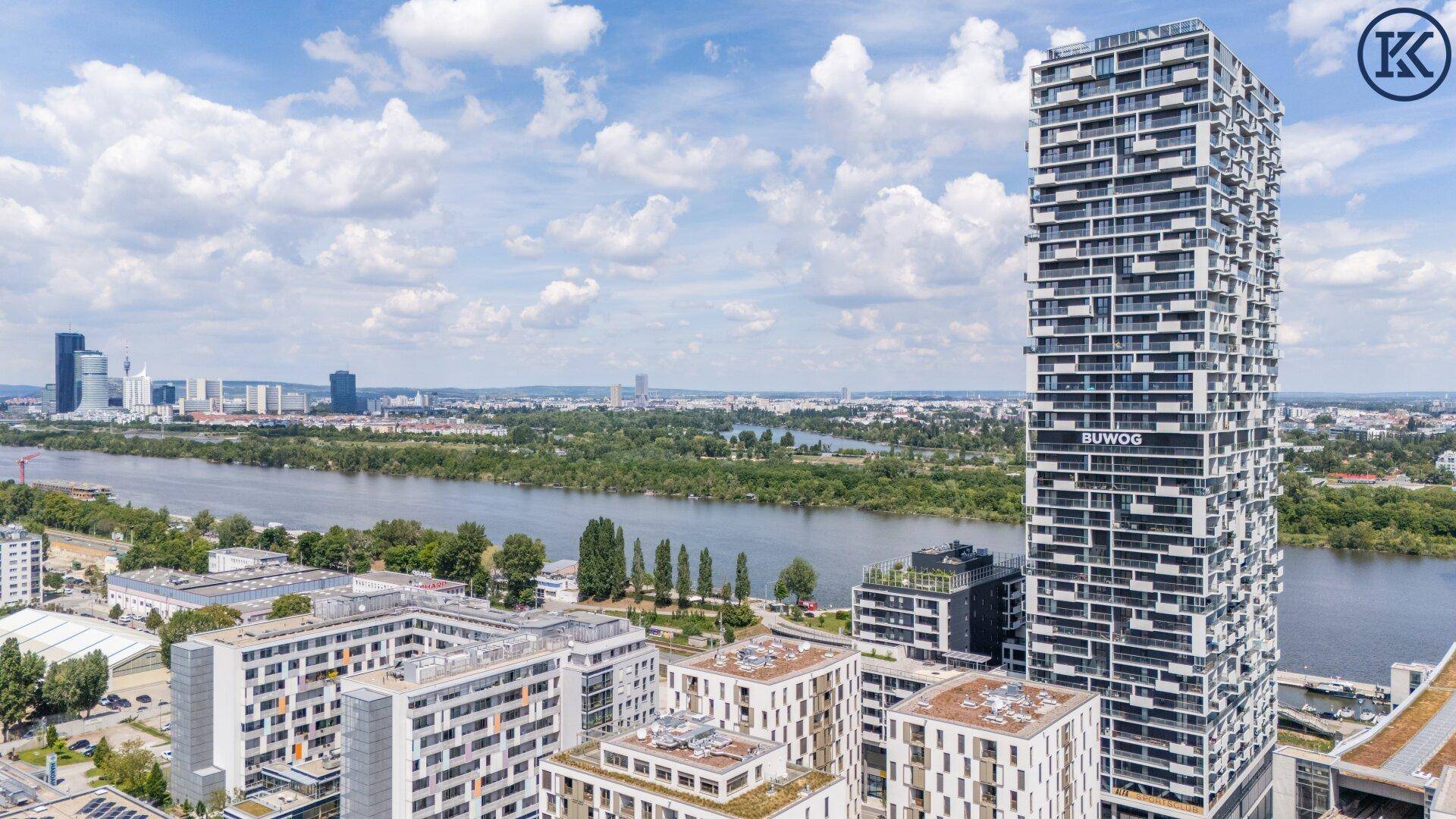 Panoramablick auf das moderne Hochhaus und die umliegende Stadtlandschaft mit Fluss.