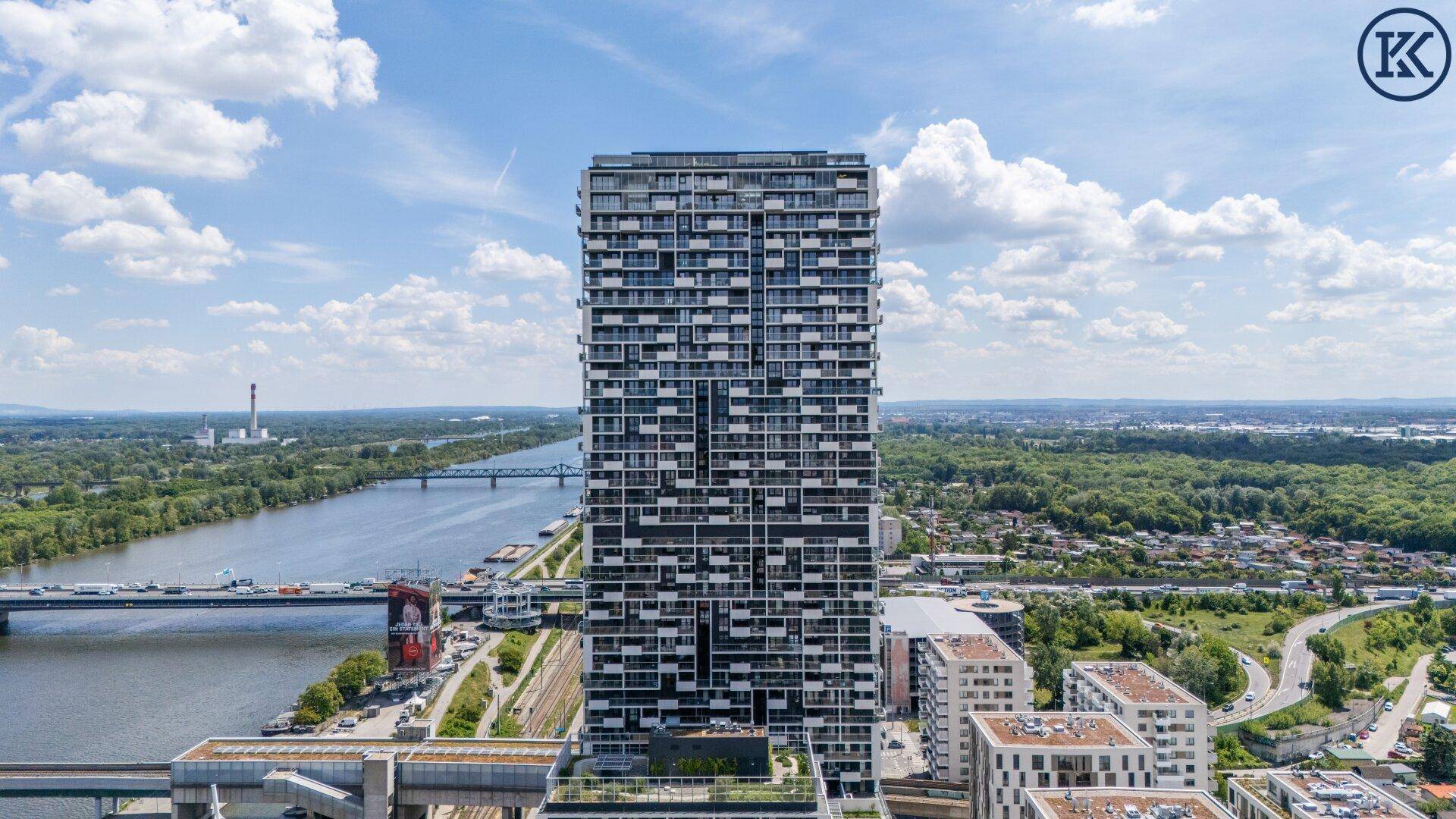 Moderner Hochhauskomplex mit vielen Balkonen und Blick auf die Donau und die Umgebung.