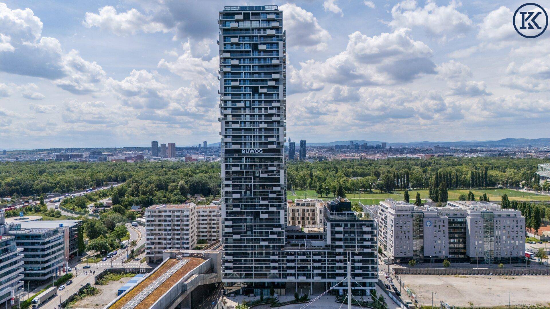 Hohes Wohngebäude mit markanter Fassade und Panoramablick auf die Stadt und Grünflächen.
