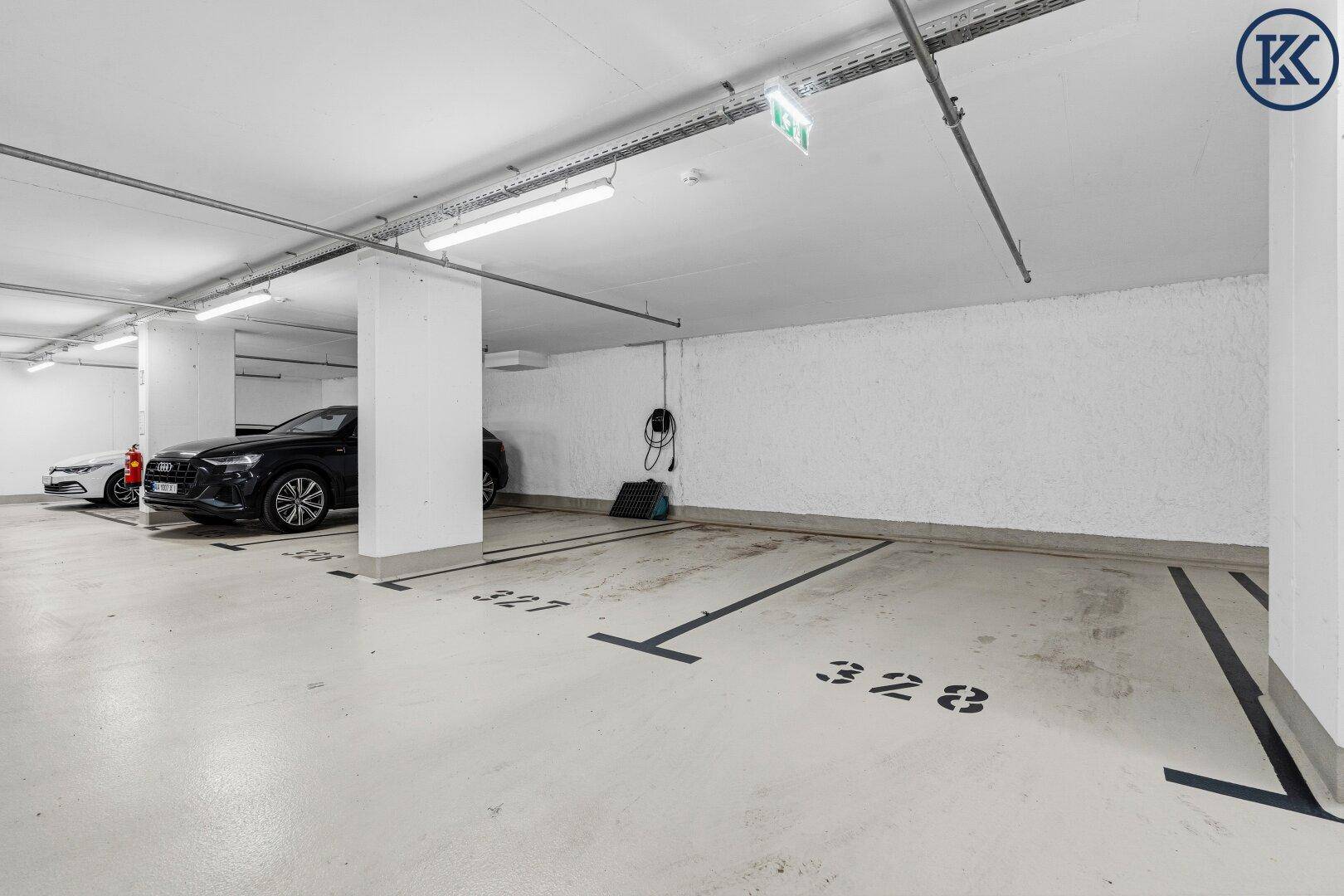 Tiefgarage mit markierten Stellplätzen und Ladestation für Elektrofahrzeuge.