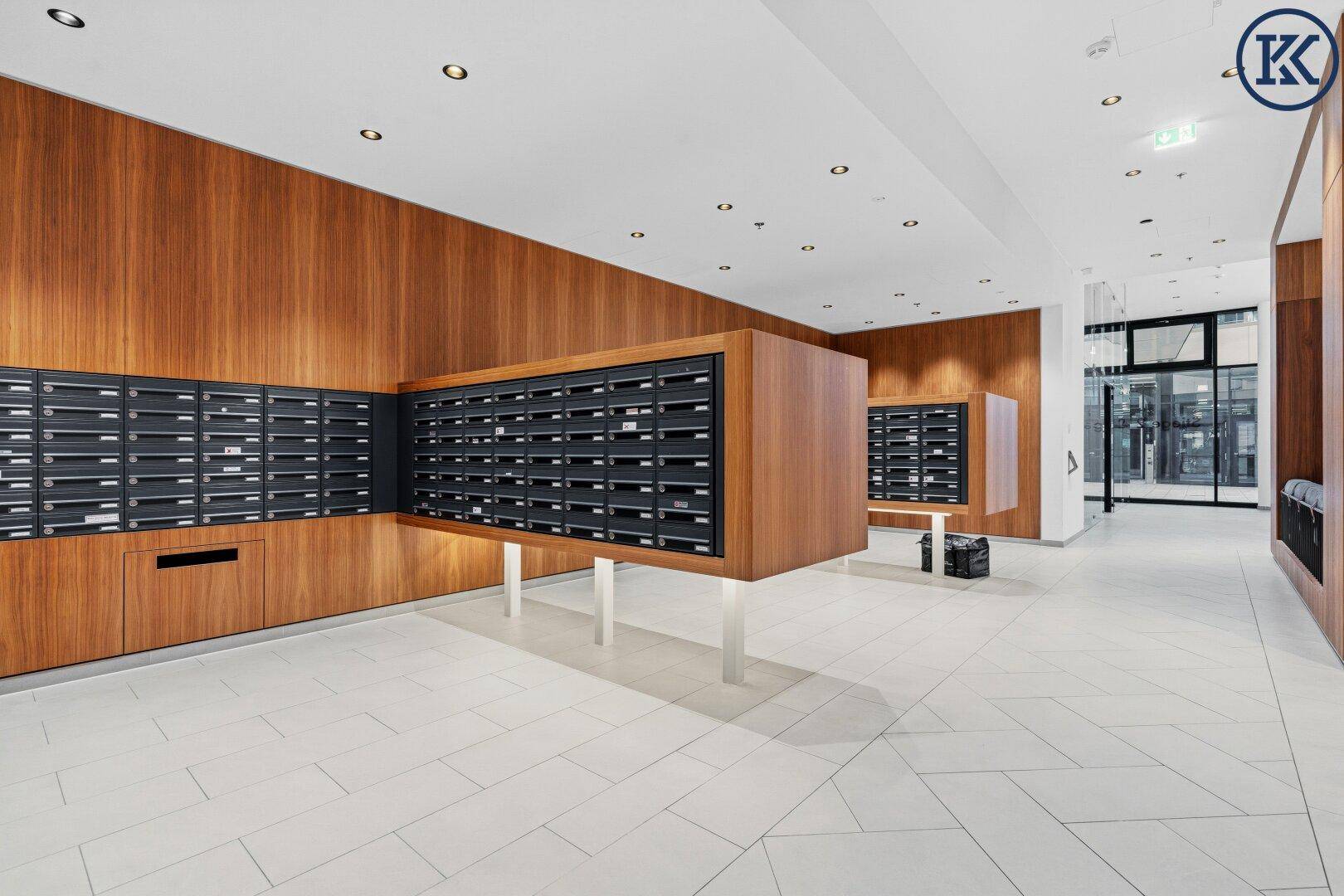 Heller Flur mit modernen Briefkästen und eleganter Holzverkleidung im Eingangsbereich.