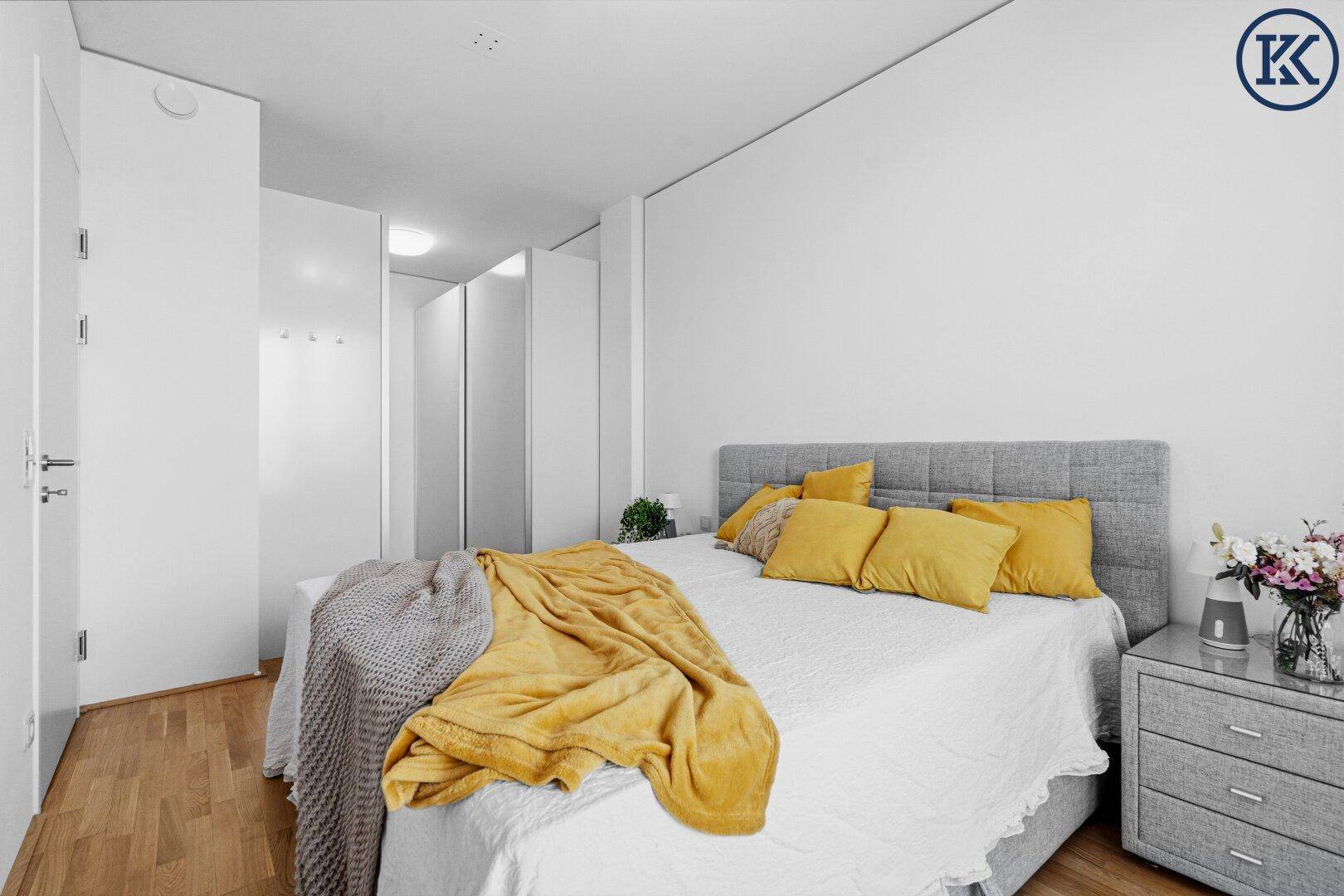 Gemütliches Schlafzimmer mit Holzboden, Doppelbett und integrierten Kleiderschränken.