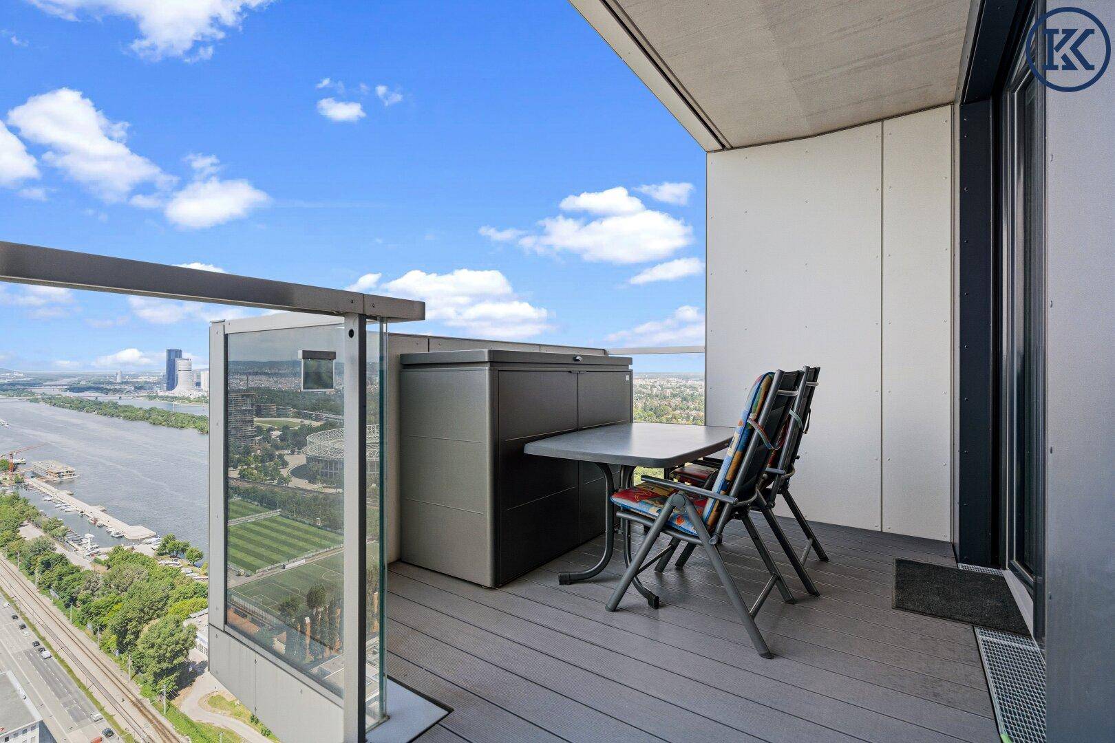 Balkon mit Esstisch und Stühlen, ideal für Mahlzeiten im Freien mit Fluss- und Stadtblick.