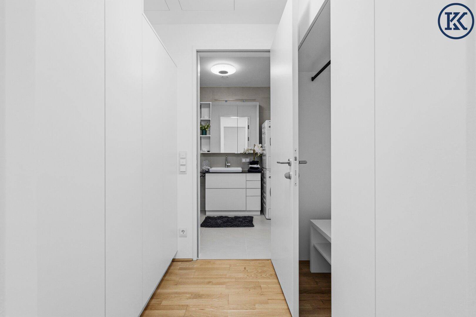 Heller Flur mit Holzboden und Zugang zu einem modernen Badezimmer.