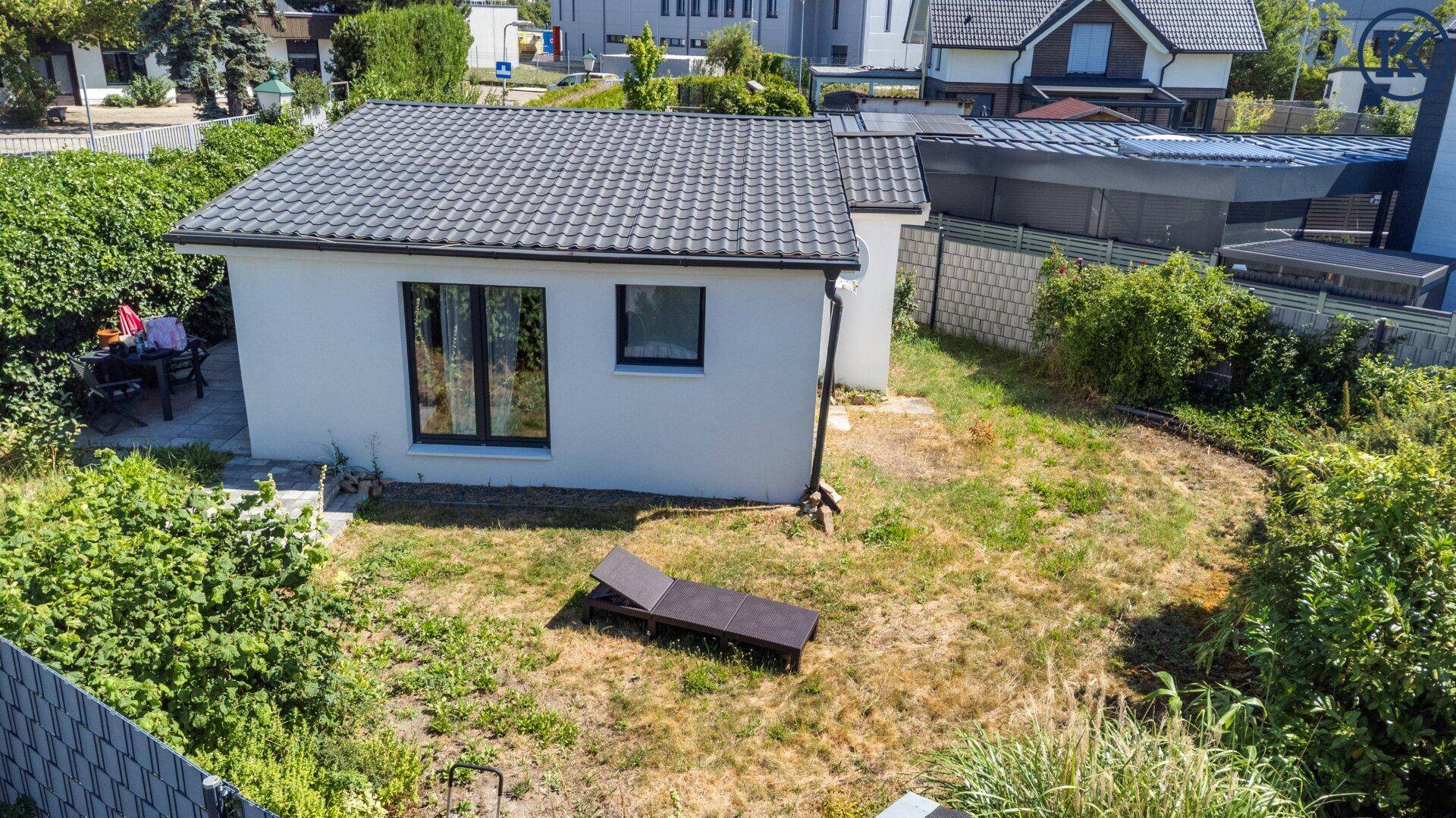 Luftaufnahme des Hauses und des Gartens aus einer anderen Perspektive, mit Liegestuhl im Gras.