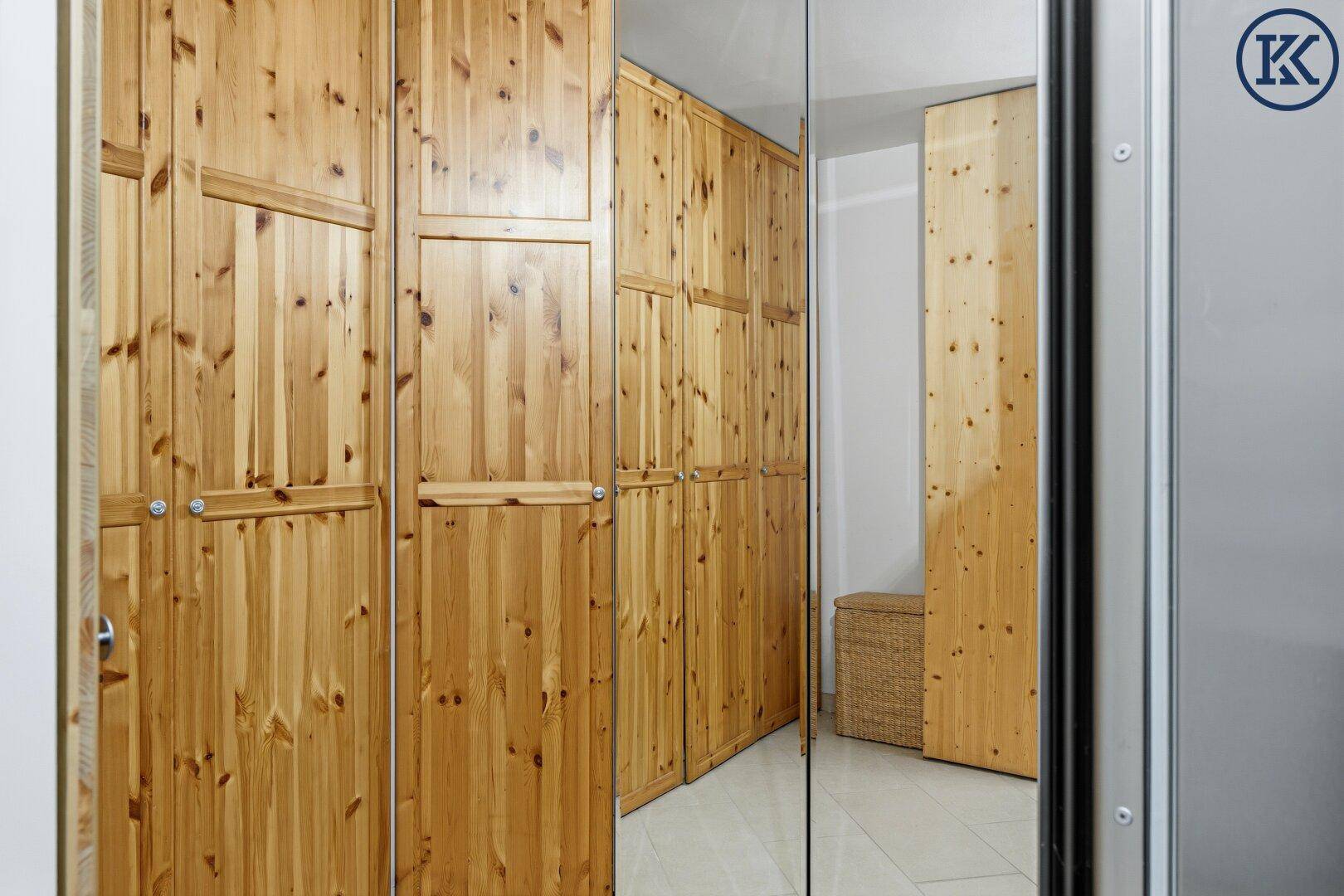 Flur mit eingebauten Holzschränken und Spiegeltüren, die den Raum optisch vergrößern.