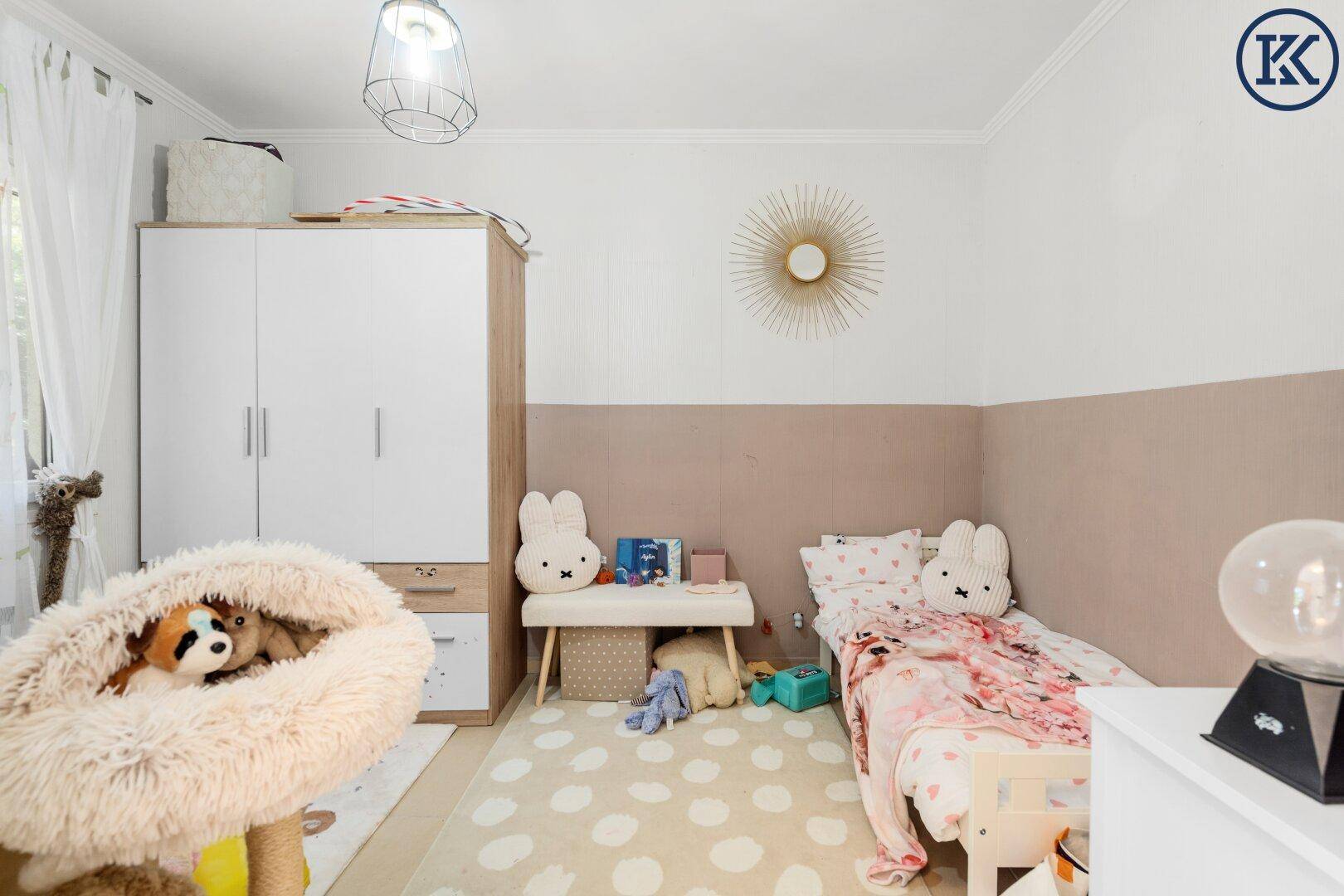 Kinderzimmer mit Einzelbett, Kleiderschrank und spielerischer Dekoration.