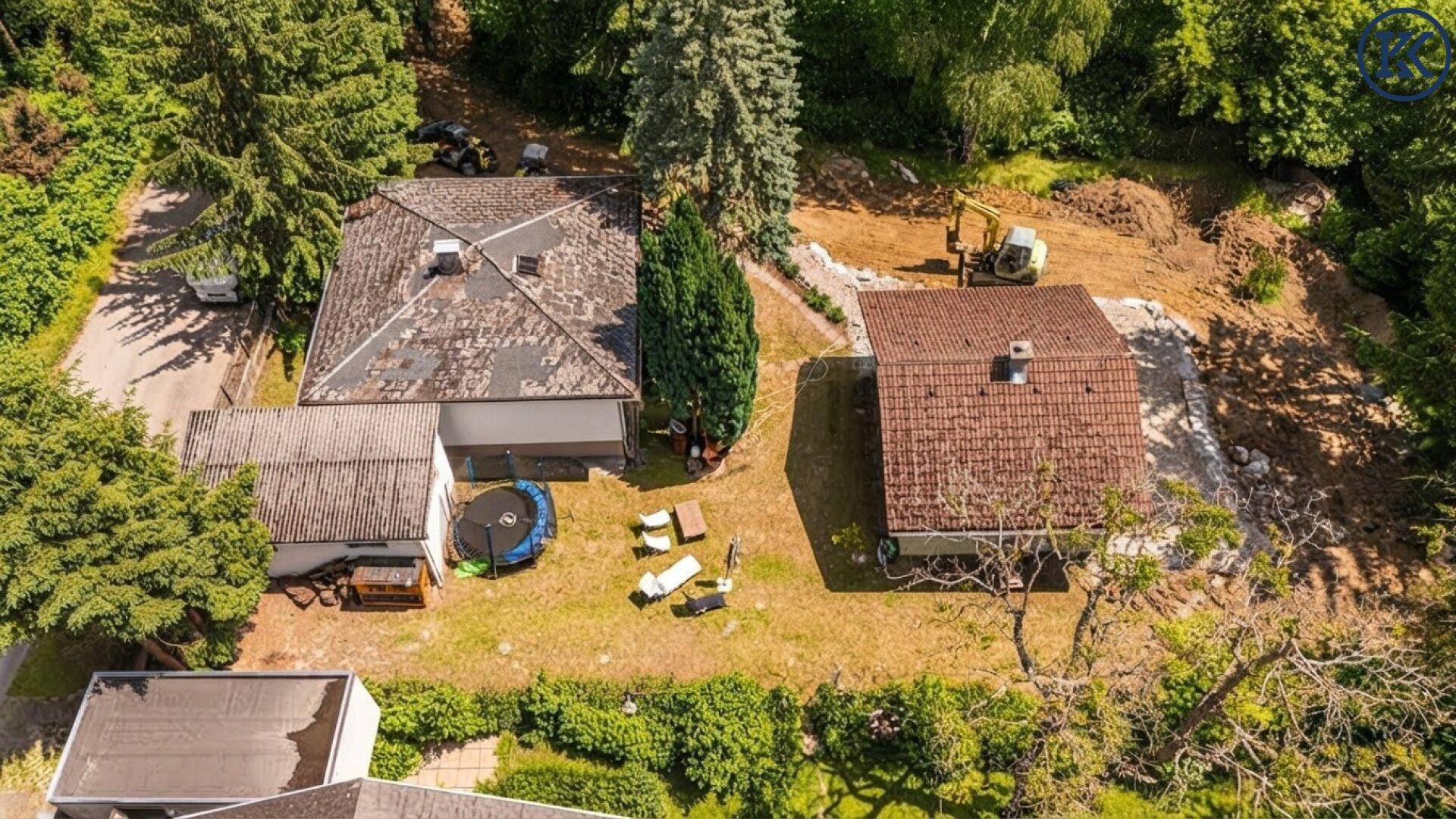 Luftaufnahme des Anwesens mit zwei Häusern und Bauarbeiten im Gartenbereich.